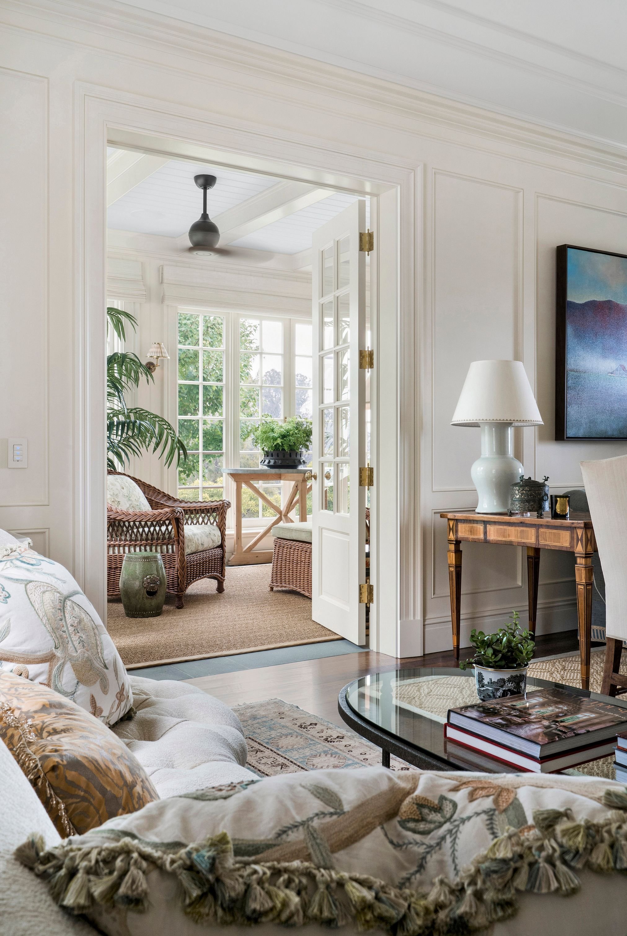 Sunroom through the doorway with rattan chairs and garden view