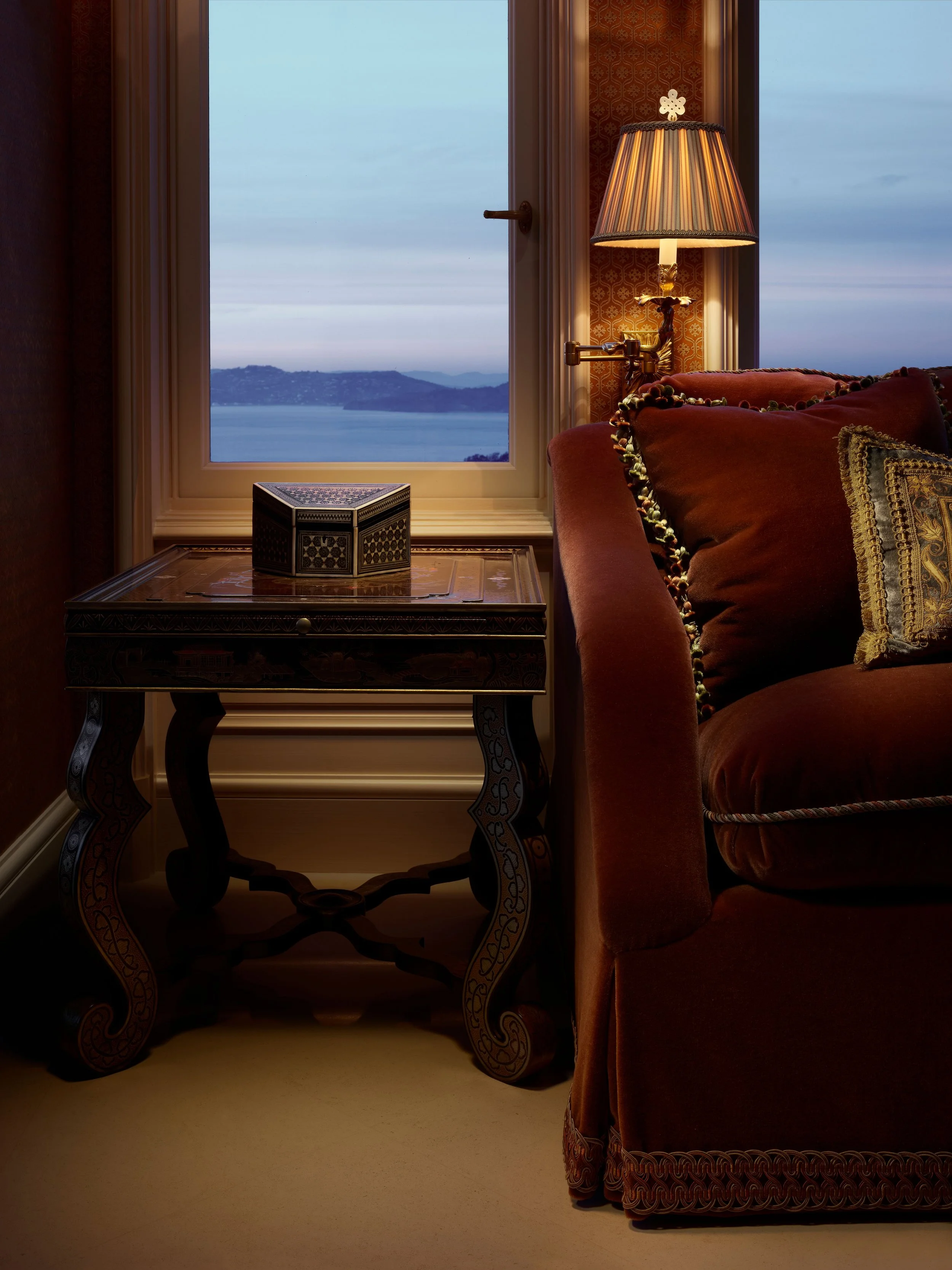 Corner with antique console, red velvet armchair, and water view, Classic French Apartment

