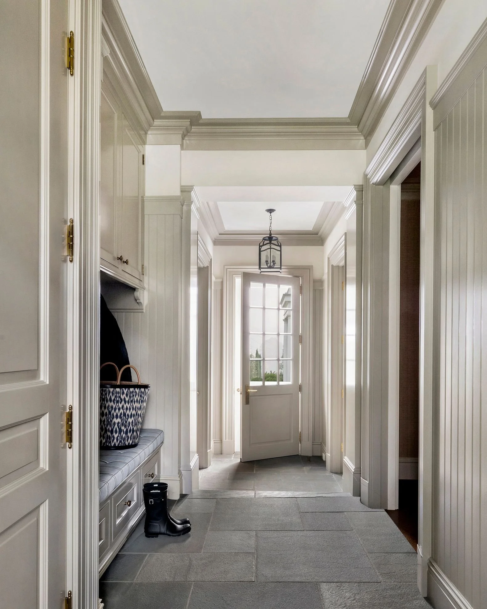 Paneled hallway with pendant lanterns leading to the garden door