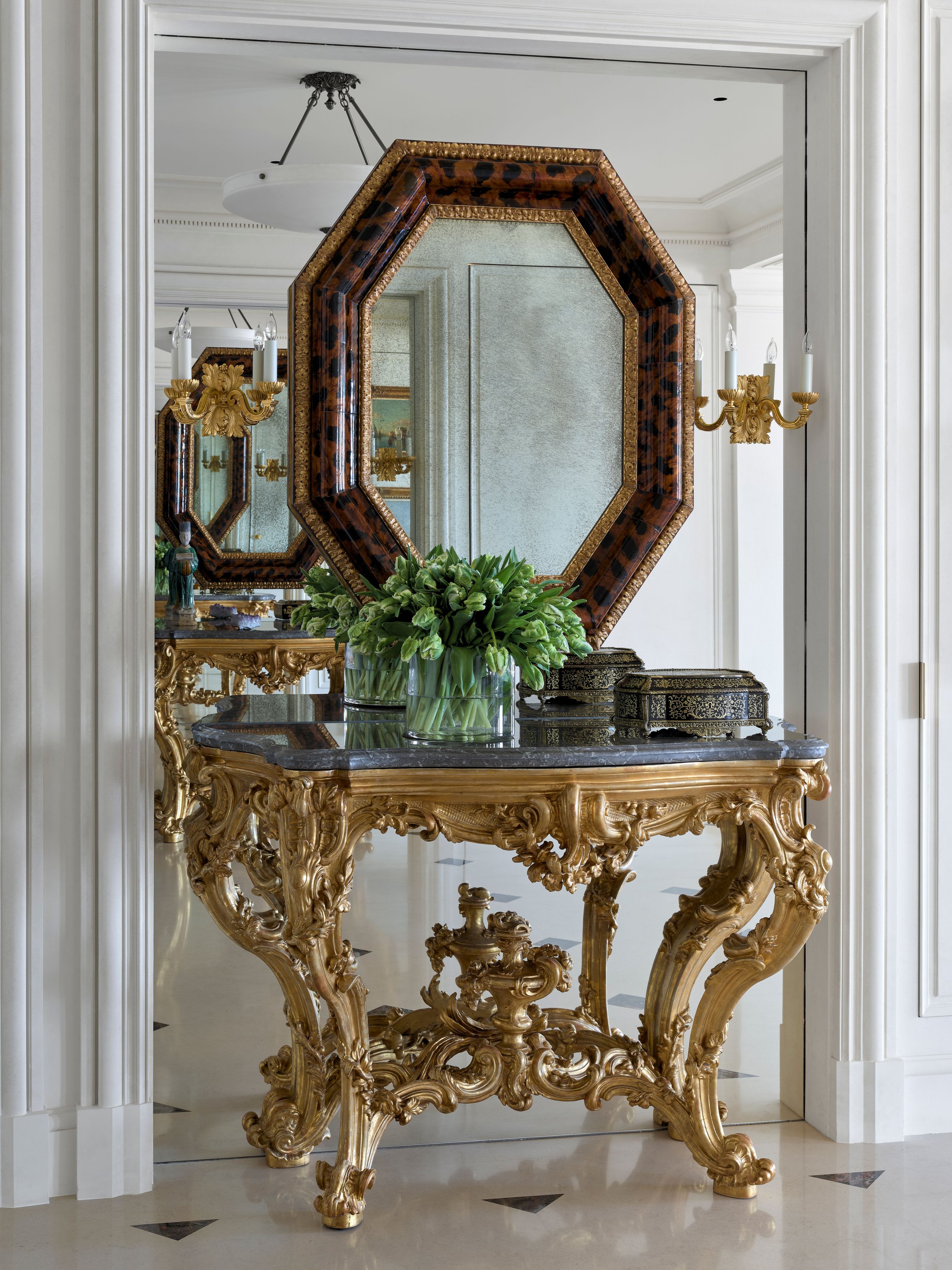 Octagonal mirror above a gilt rococo console with greenery, Classic French Apartment