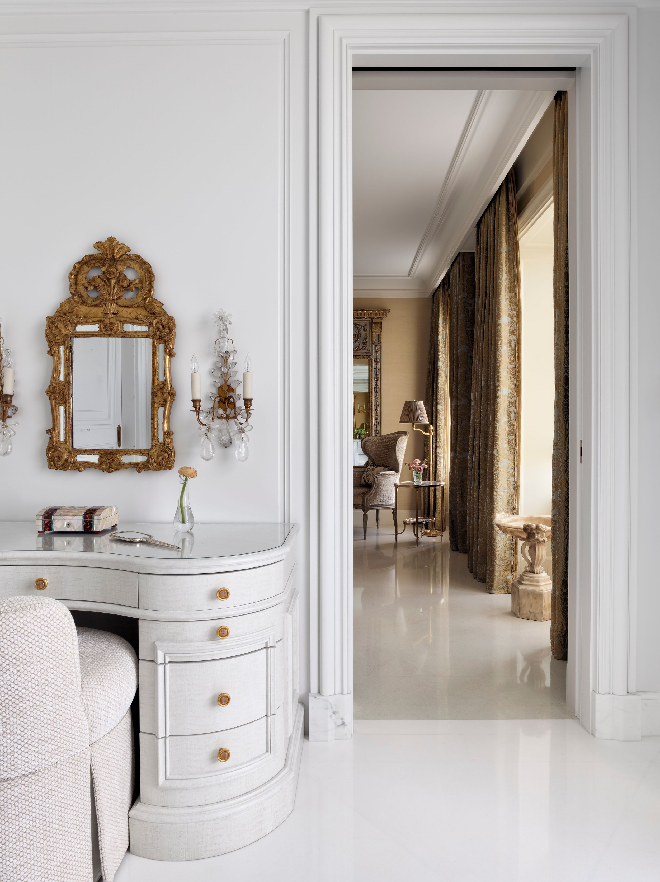 Dressing vanity with gilt mirror and view down the hallway