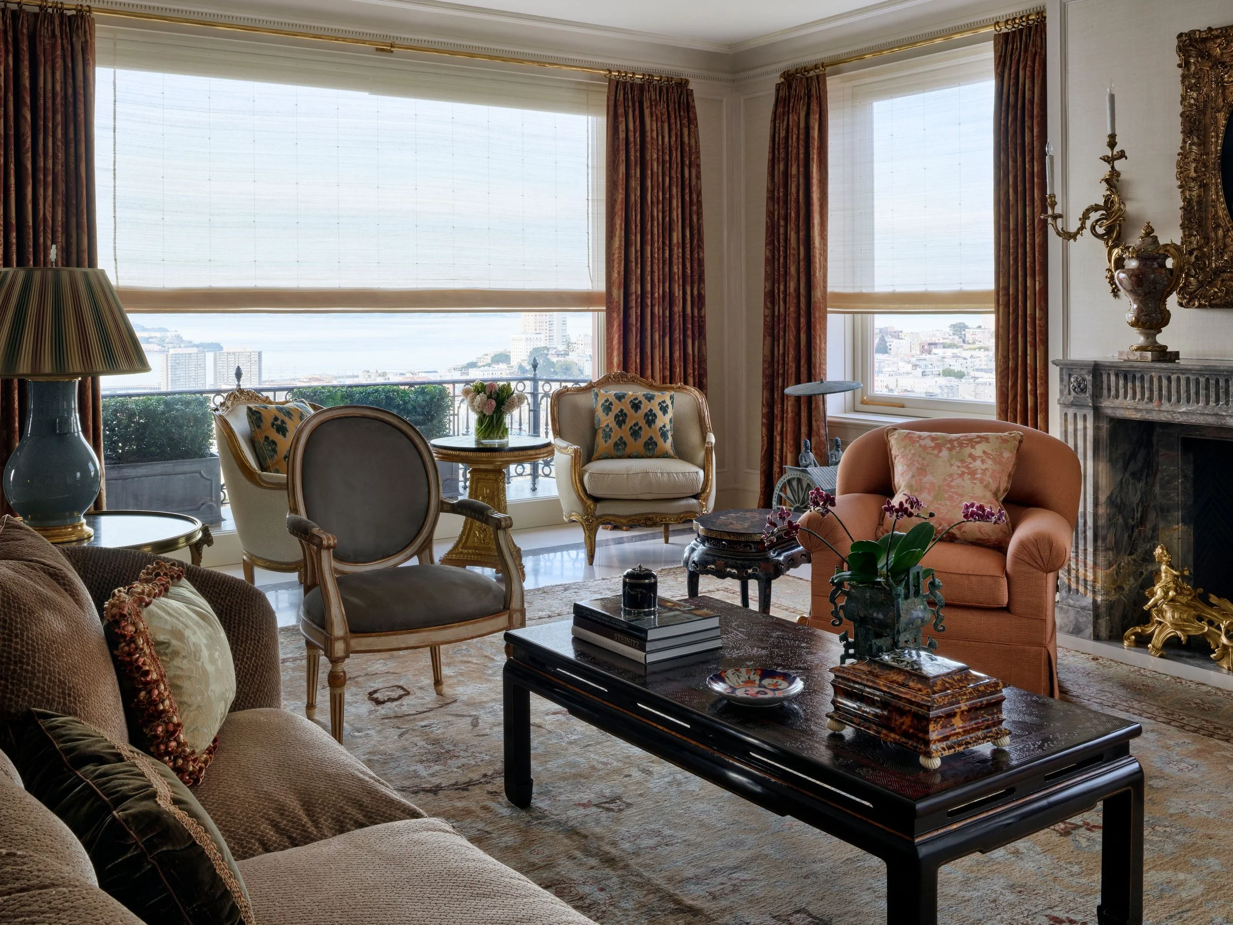 Living room with apricot armchairs, black lacquered coffee table, and bay windows