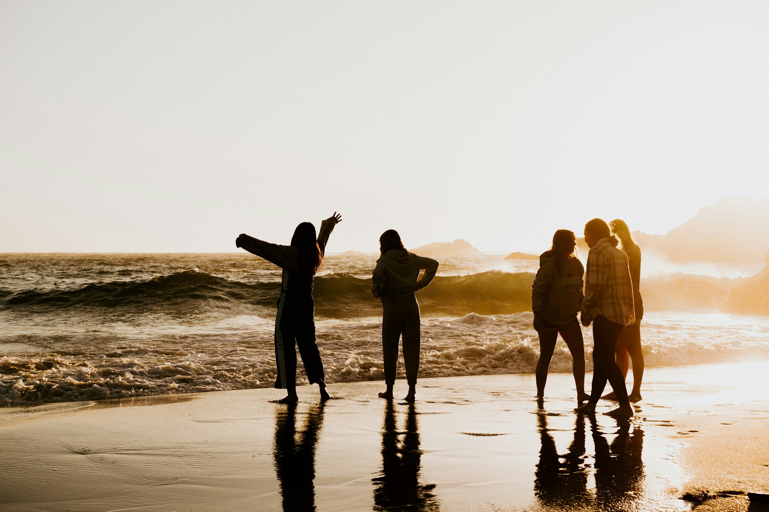 Group of teenage friends enjoying connection at the beach, reflecting the growing independence, friendships, and self-discovery of adolescence, while navigating the desire for both parental support and the freedom to explore life on their own terms.