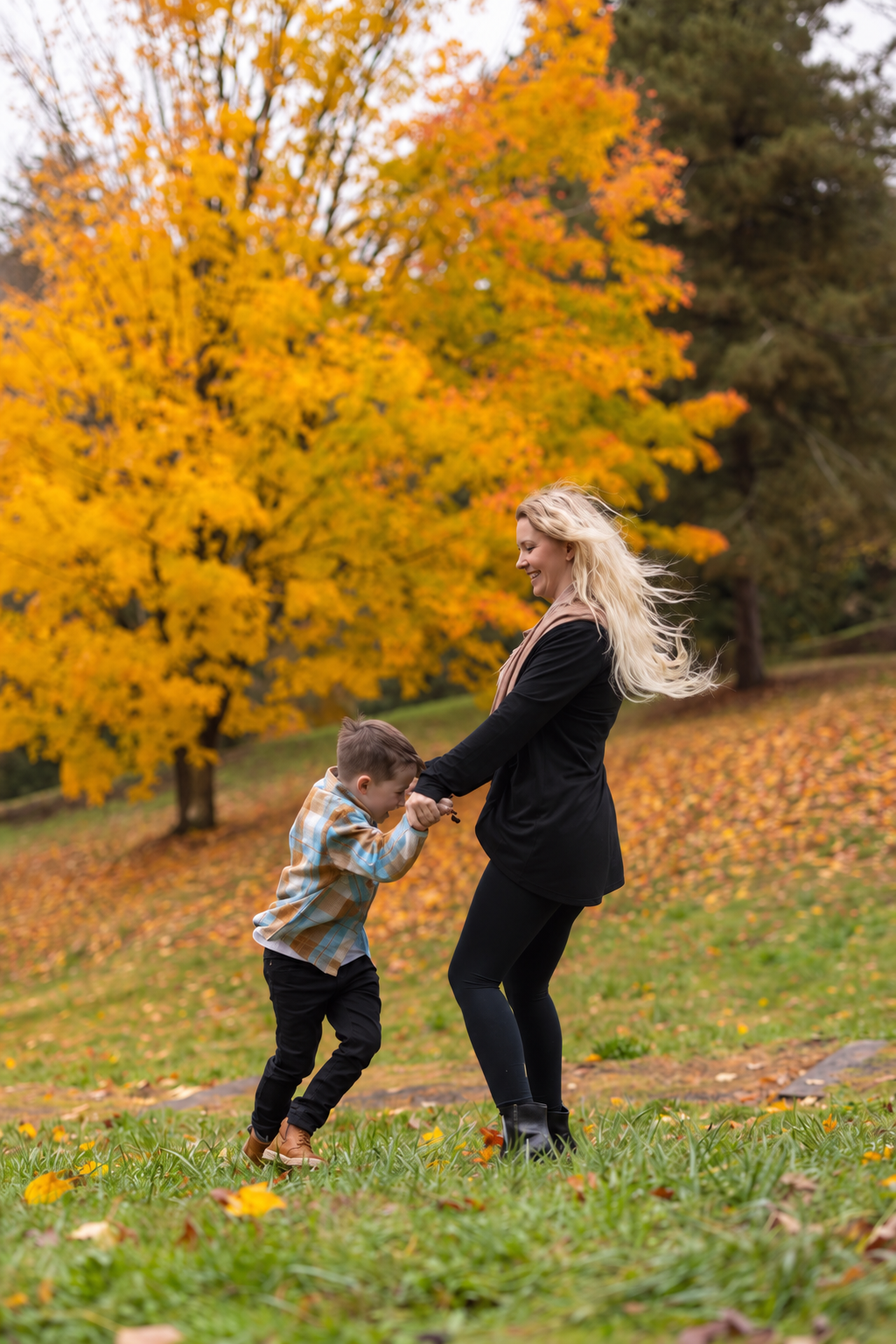 Natalie Williamsen, LCSW, sharing a playful moment with her son outdoors, reflecting the personal connection to family and neurodivergence that informs her therapeutic approach.