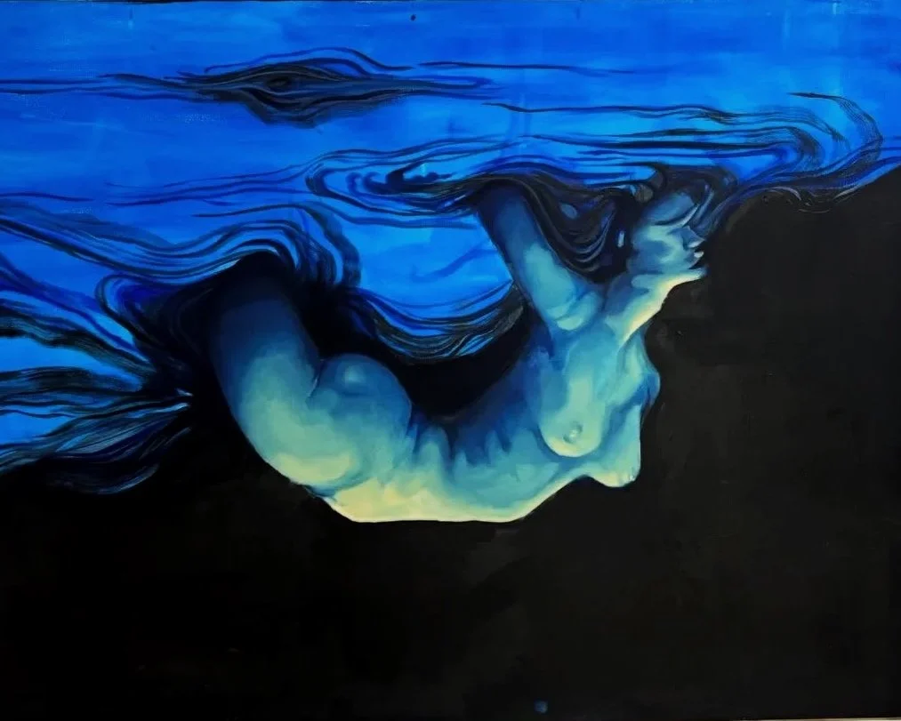 Close-up of a person's face underwater, with their head turned downward, surrounded by flowing blue water and water effects.