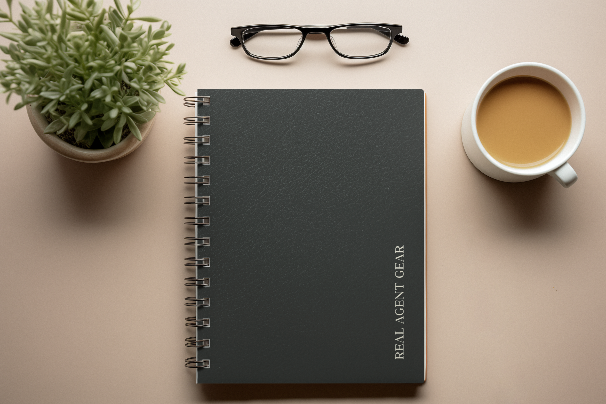 A flat lay of a potted succulent plant, a pair of black glasses, a black spiral-bound notebook labeled 'READING MATERIAL,' and a white mug filled with coffee on a beige surface.