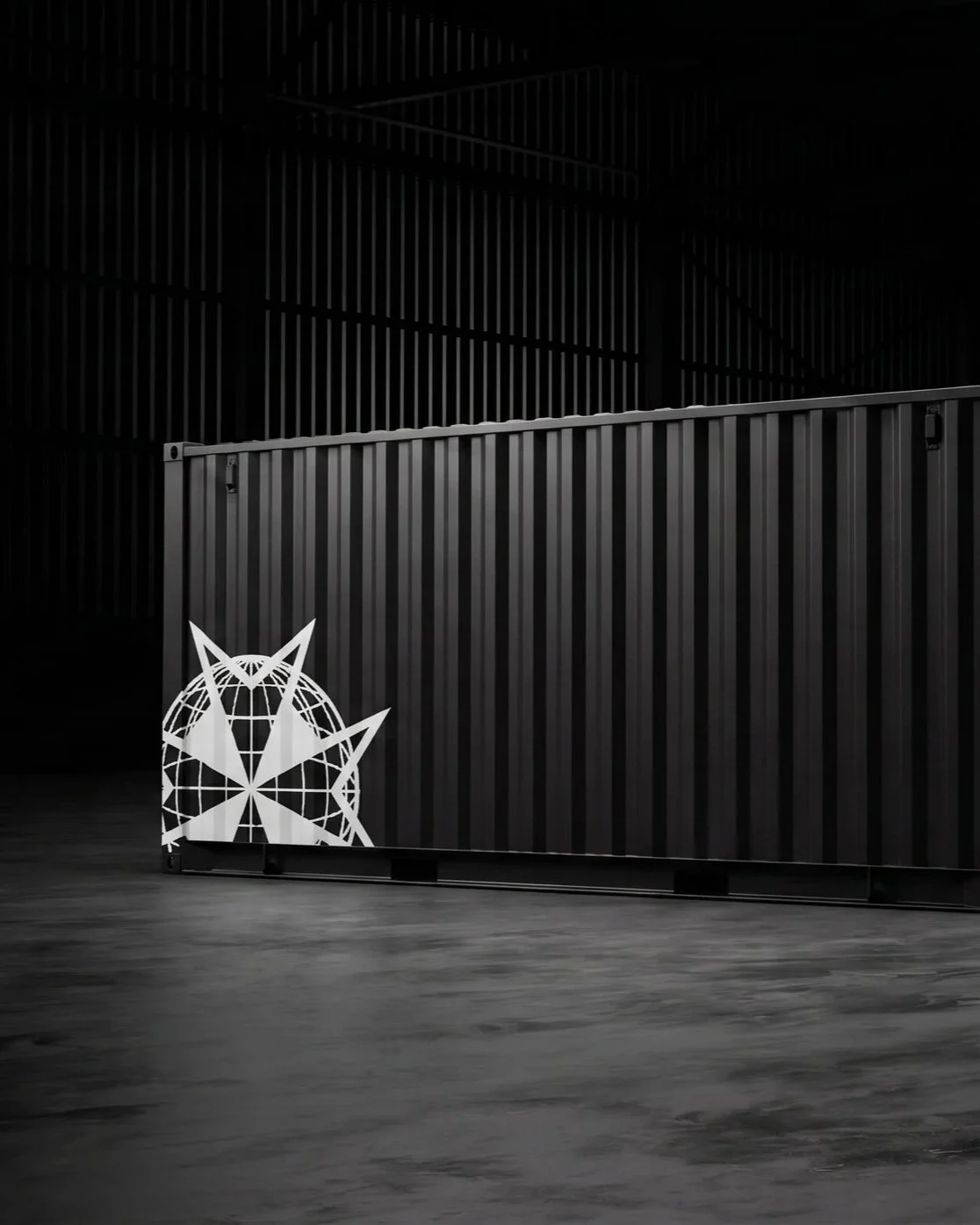 A black shipping container with a Navigantium logo on the bottom left corner, set in a dark, industrial warehouse with wooden floors.