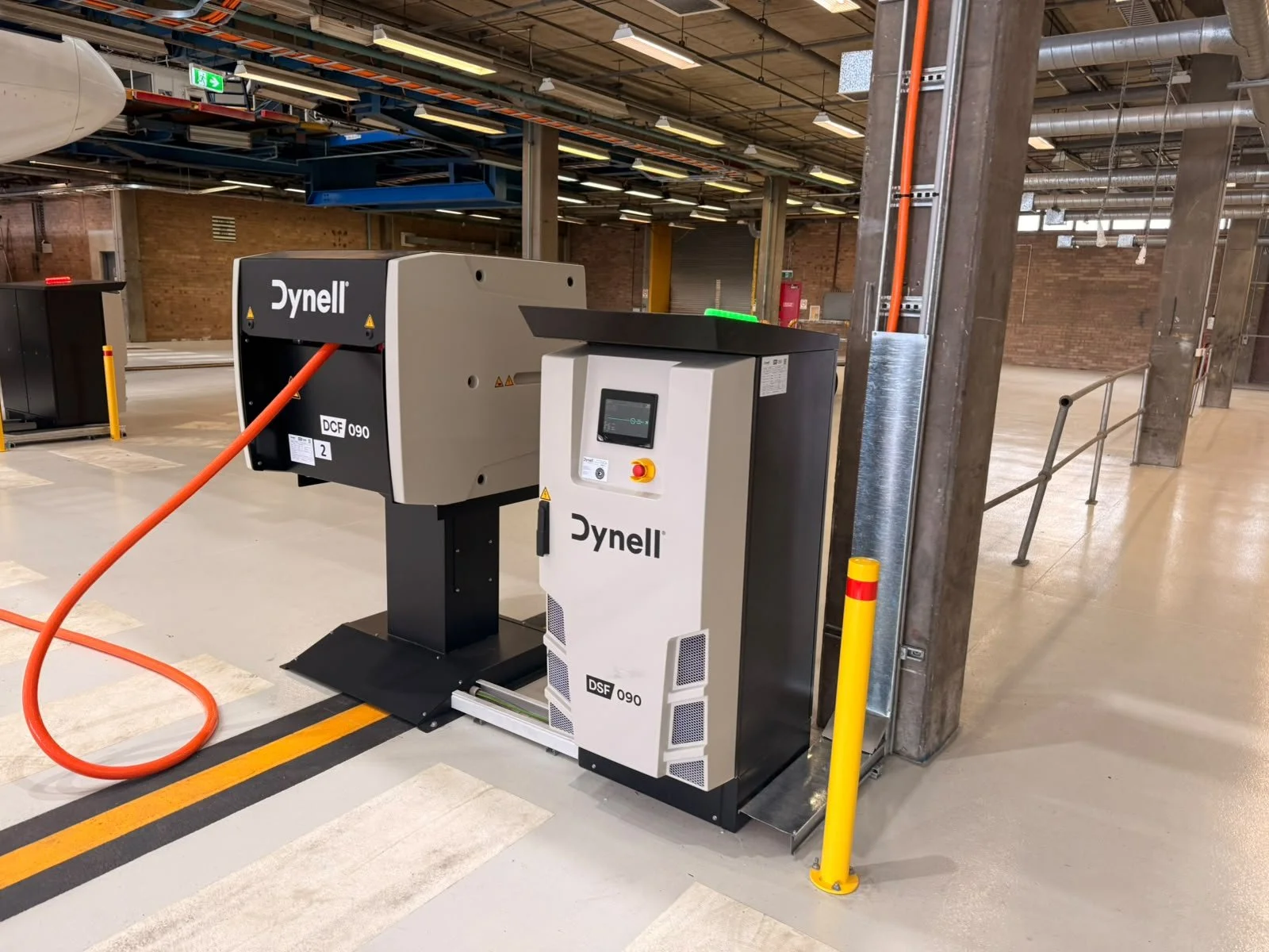 Aircraft fueling station with a Dyneell DCF 090 fuel dispenser and control panel in an industrial hangar.