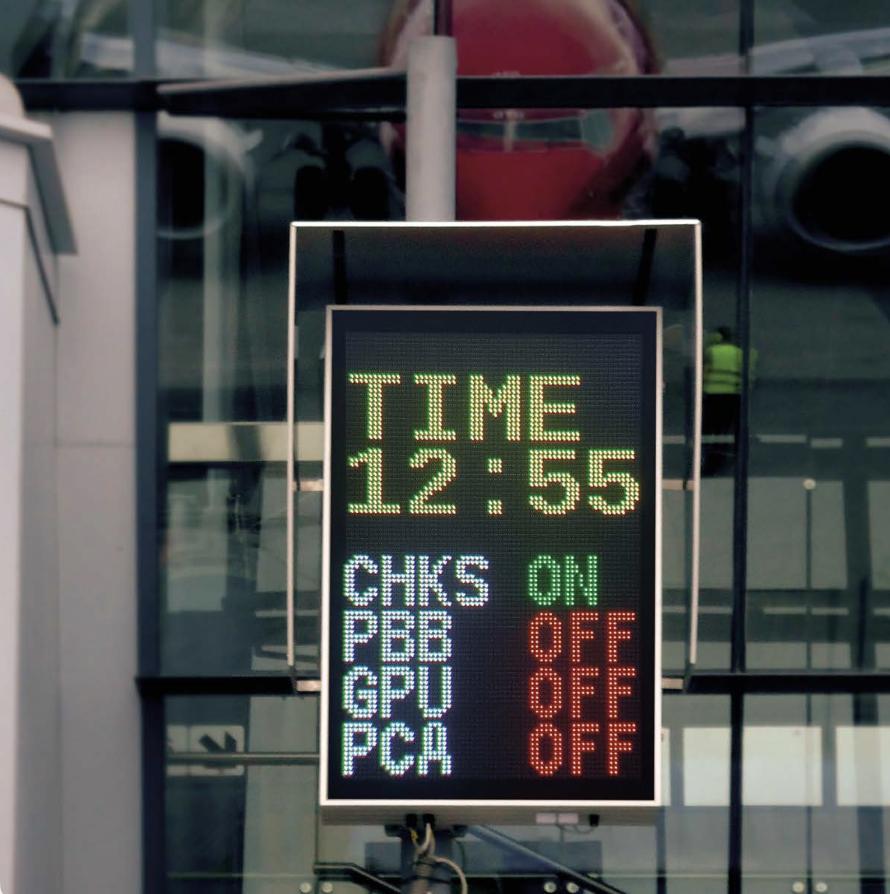 Digital sign displaying time 12:55 and various toggles labeled with abbreviations and status indicators for a Advanced Visual Docking Guidance System at an airport.