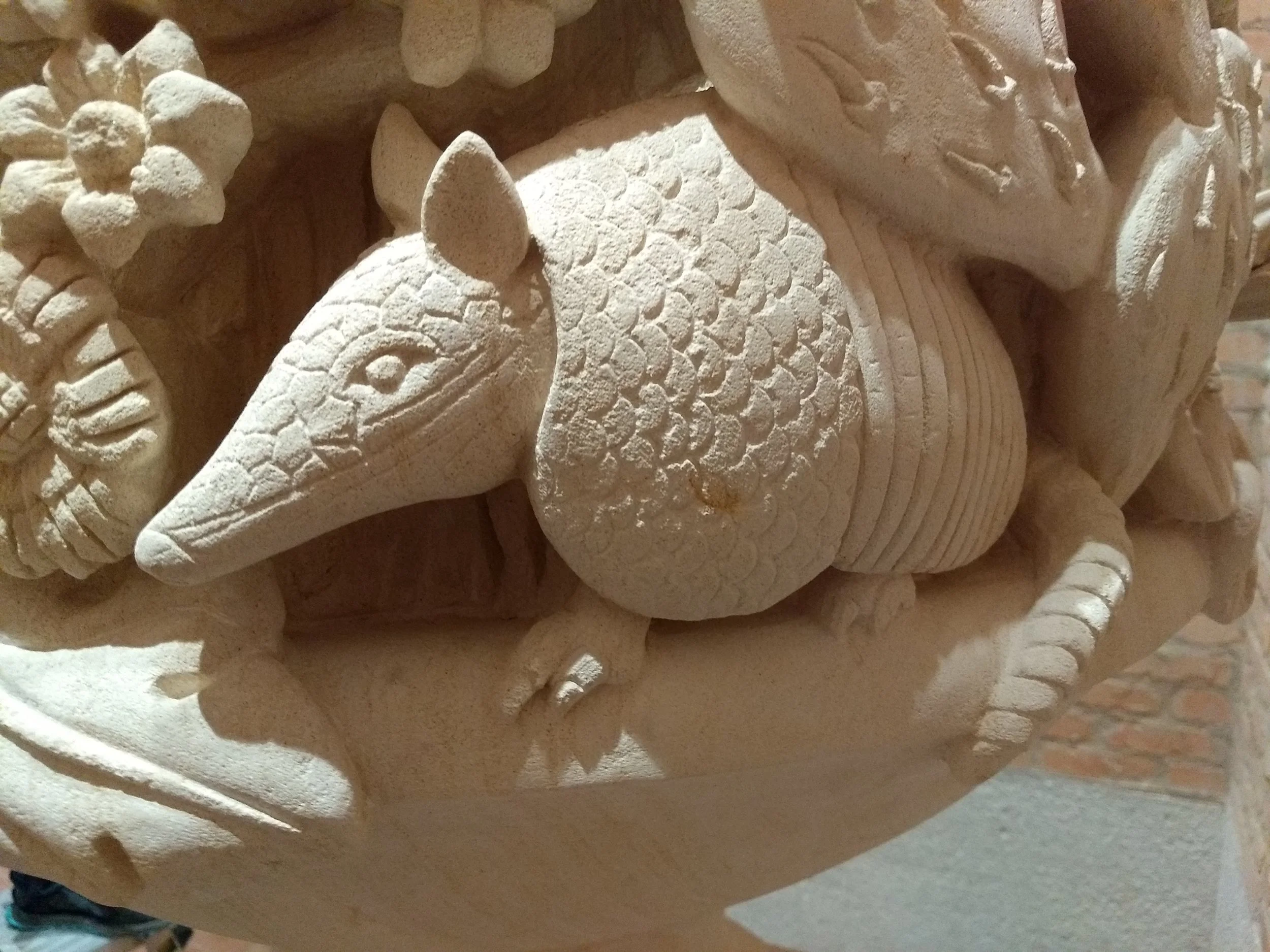 Close-up view of a detailed stone carving featuring an armadillo