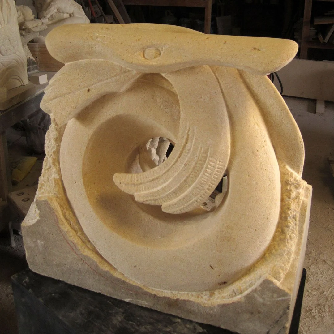 A carved stone sculpture resembling a wave or whirlpool.
