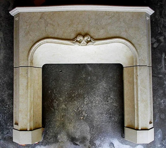 A limestone fireplace mantel with ornate detailing