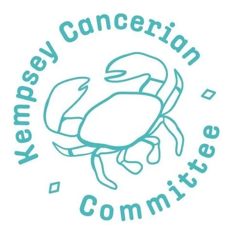 A light blue logo featuring a crab with the text 'Kempsey Cercerian Committee' encircling it.