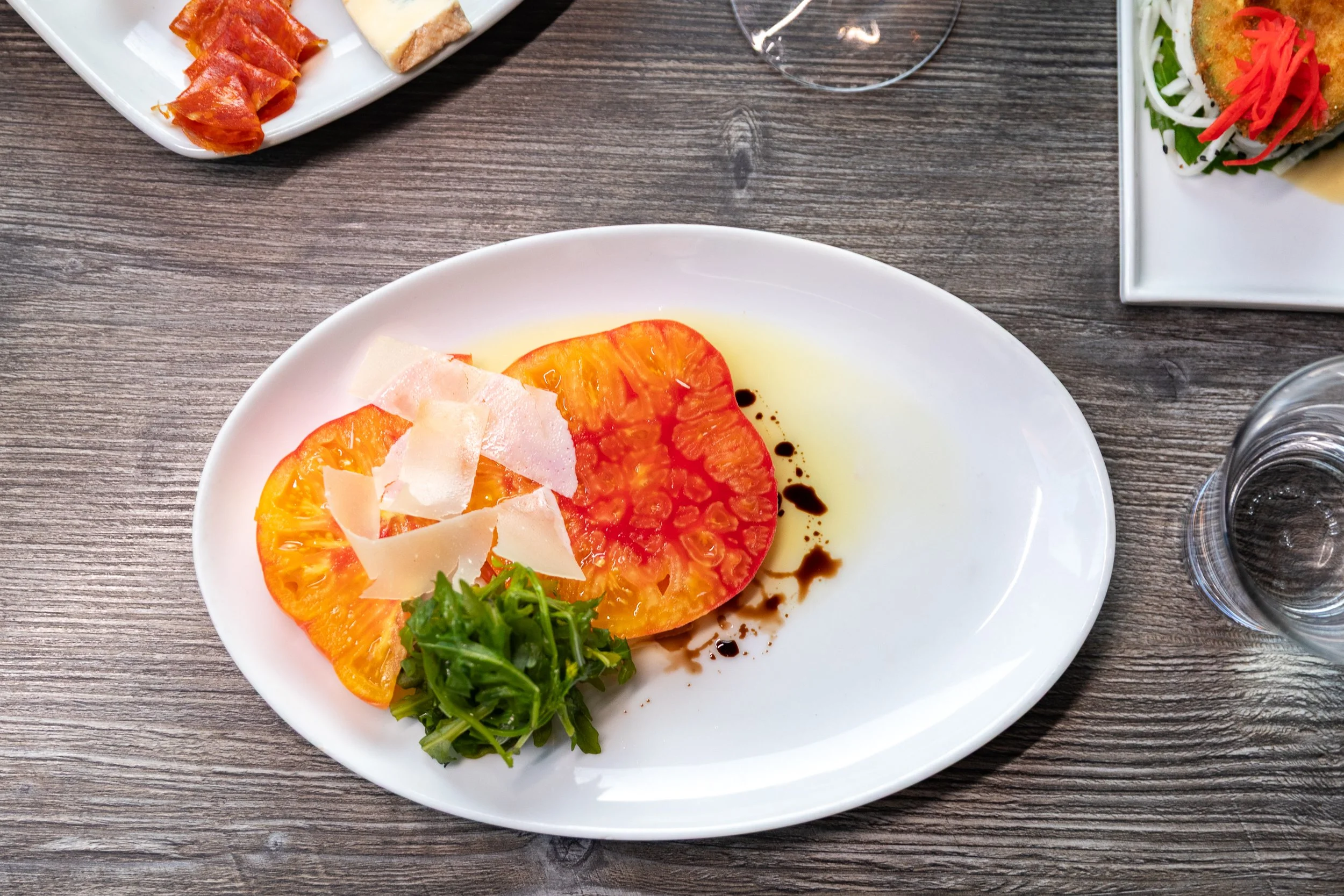 Crispy plated dish topped with shaved cheese and greens at Bacchus