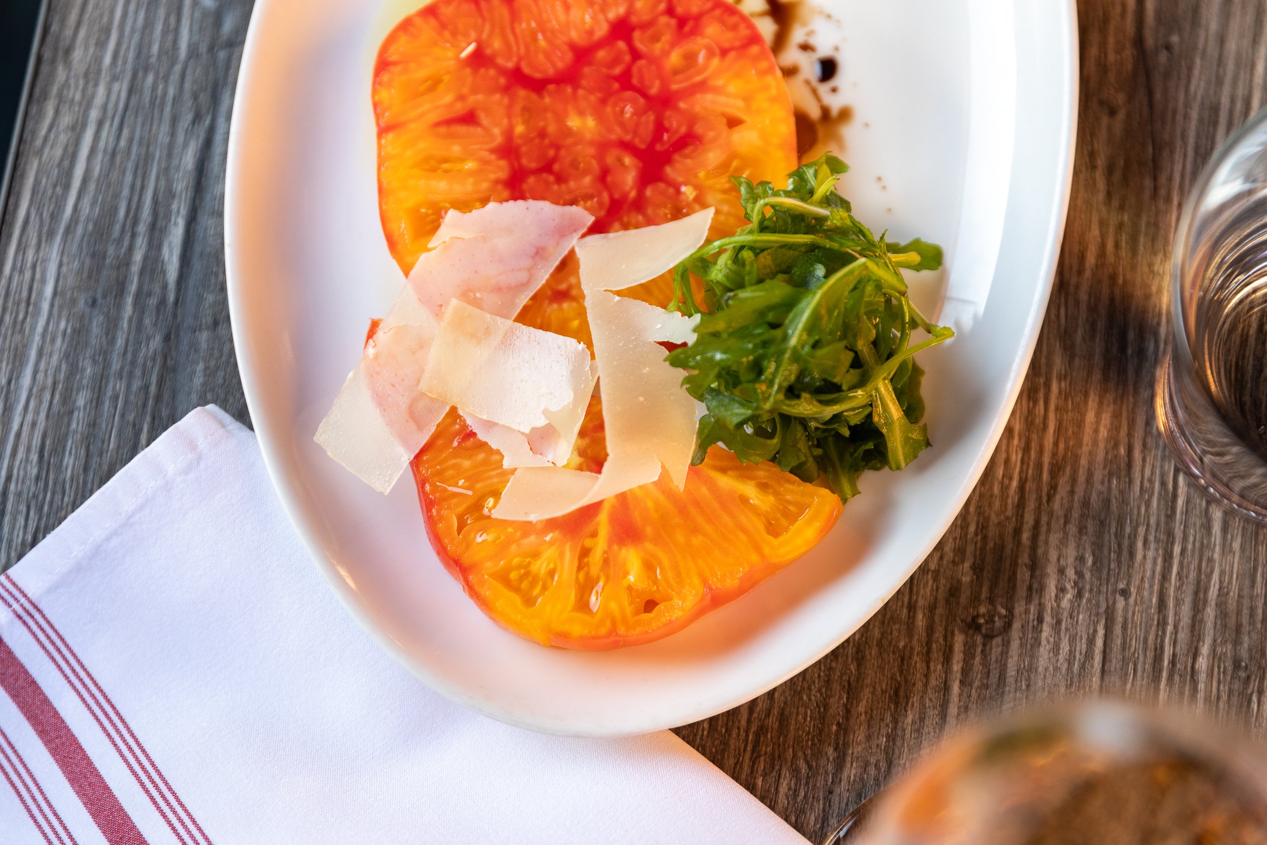 Crispy dish with shaved cheese and fresh greens for brunch catering at Bacchus