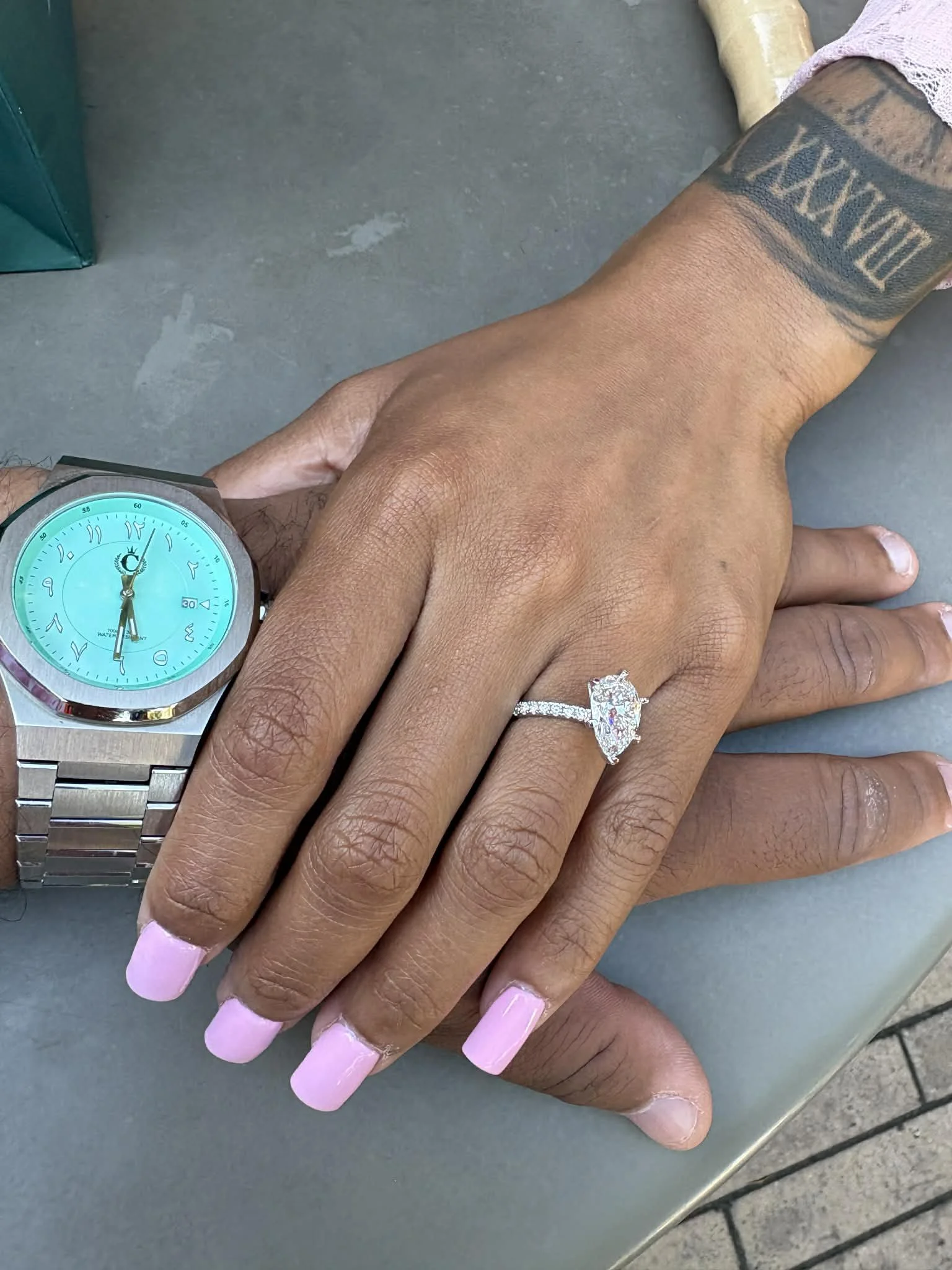 Close-up of Jazzmin’s hand wearing a ring beside Sean’s hand