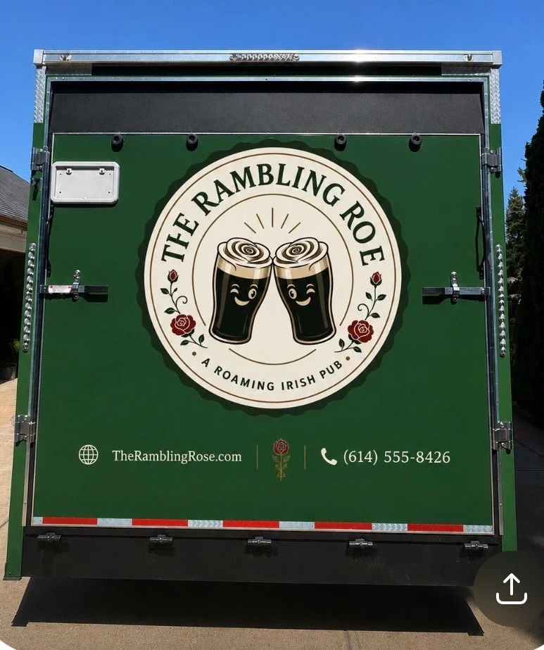 The back of a green truck displaying a logo for The Rambling Rose Irish pub with two smiling cartoon beer glasses clinking, surrounded by red roses, and contact information below.
