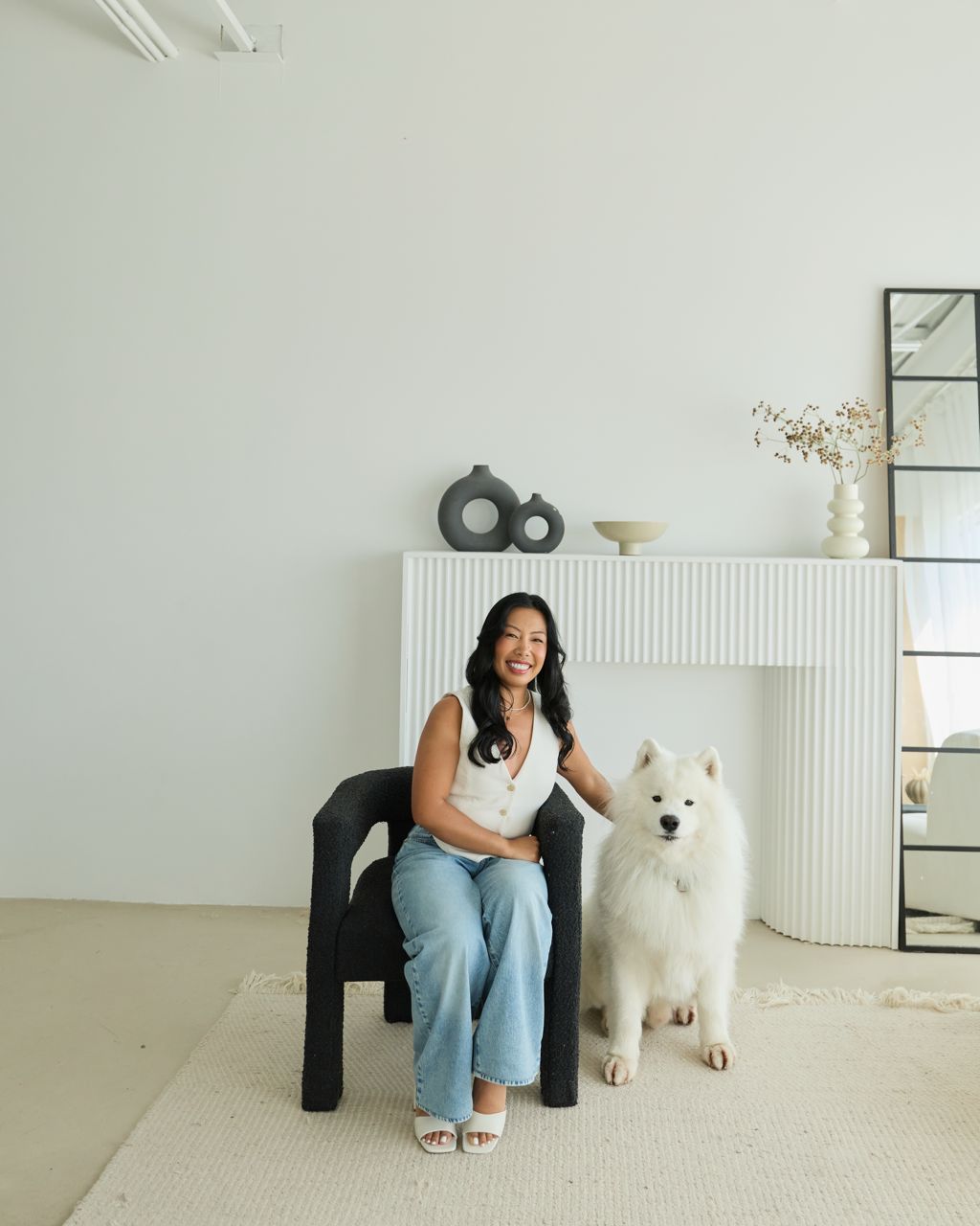 Registered Massage Therapist, Nicole Coronel, with her dog in a bright studio setting.