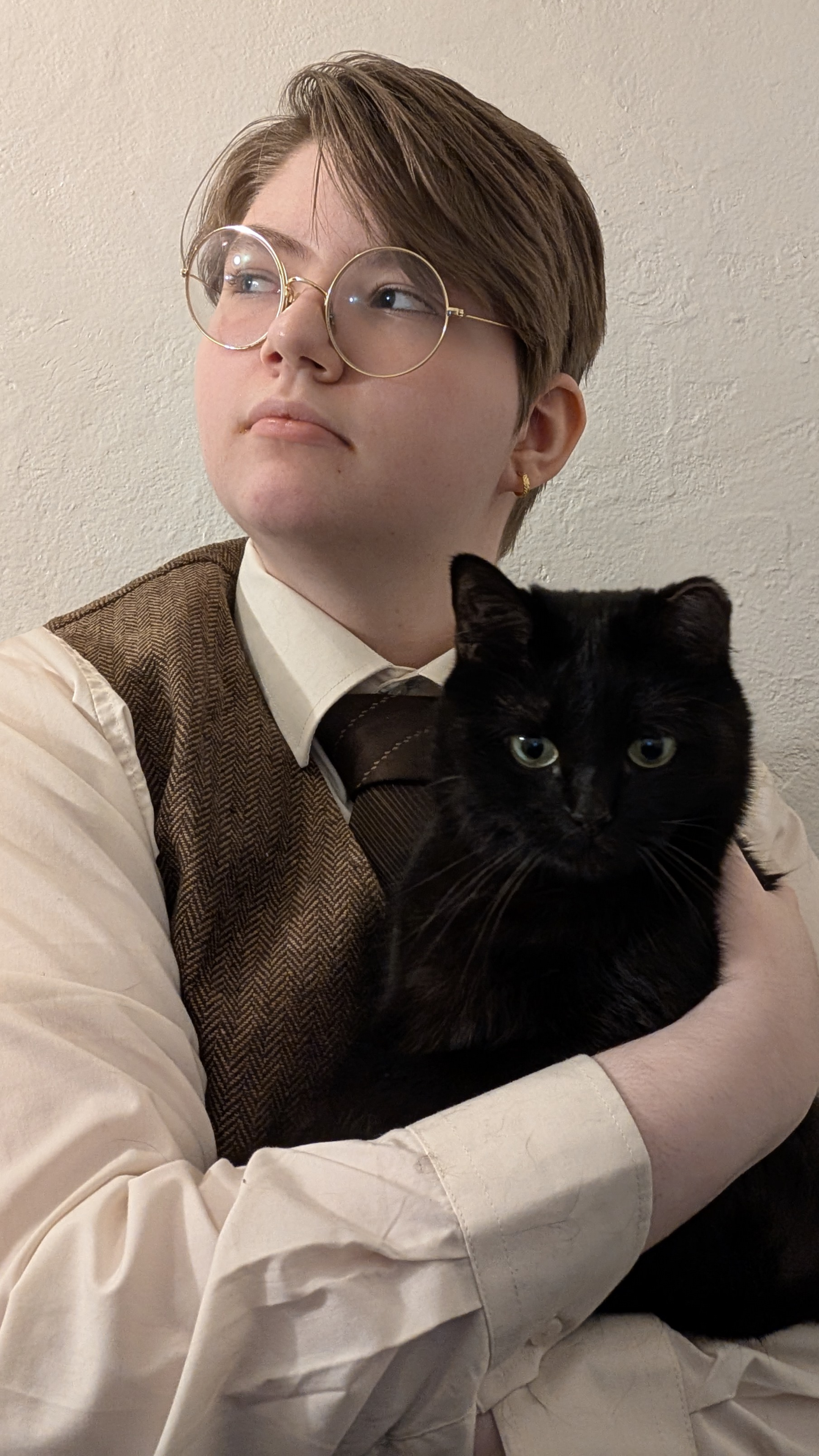 Luca Grackle looking to the upper left while holding a black cat