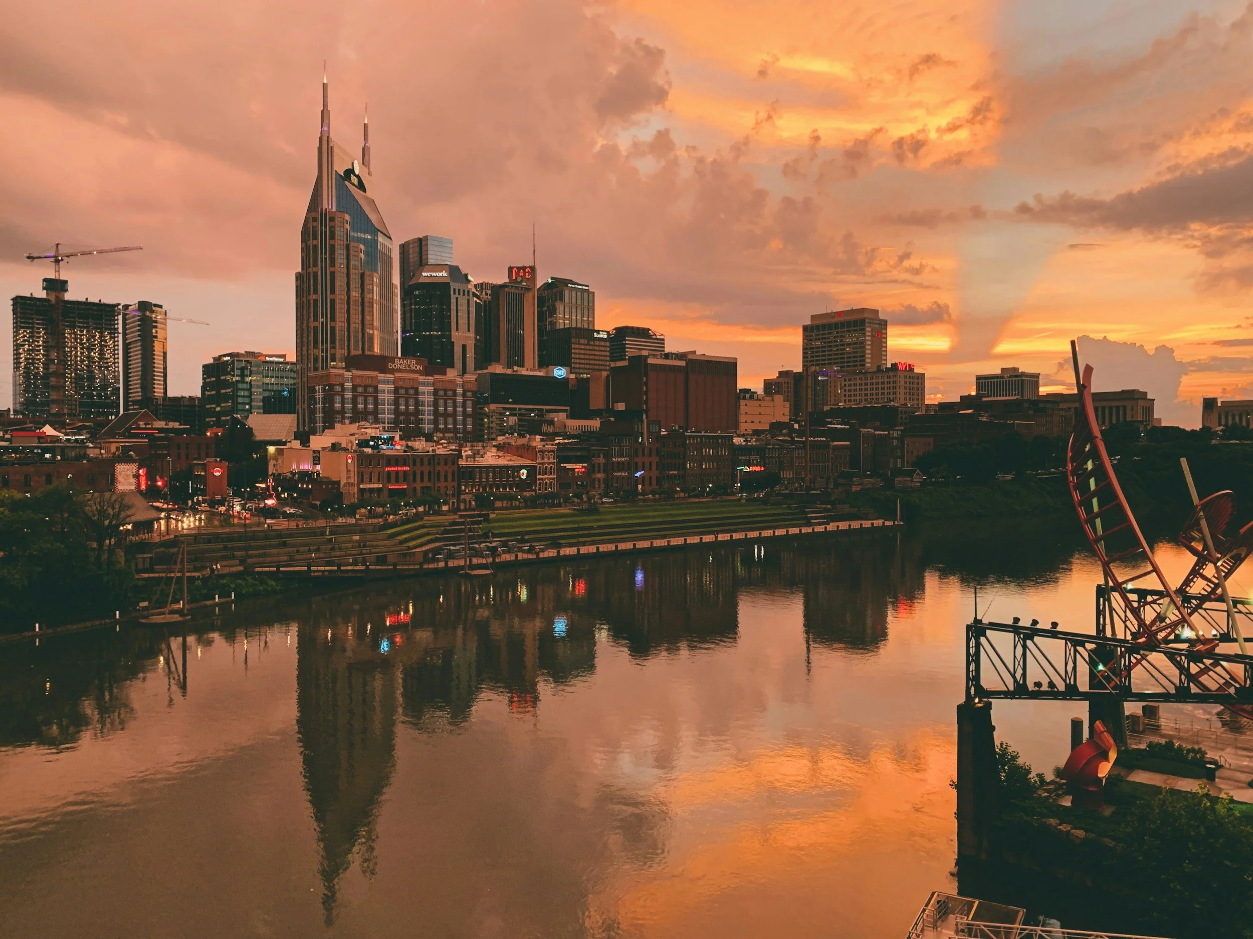 The Nashville skyline at dusk reflects on the calm waters of the Cumberland River.