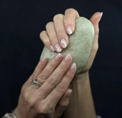 Bespoke nail art set by Roses Kustom Worx in Taupō, shown holding a stone against a dark background.