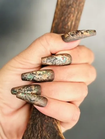 “Green and gold detailed nail art on long nails, created by Roses Kustom Worx in Taupō.”