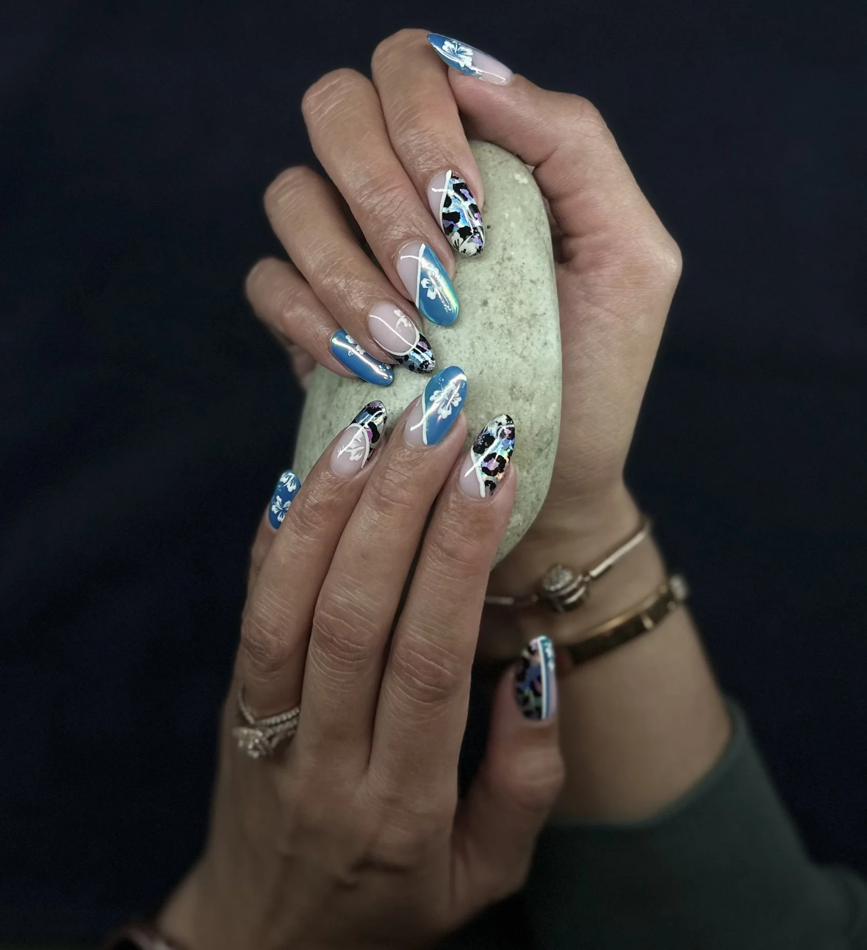 Detailed blue and white bespoke nail art by Roses Kustom Worx in Taupō, photographed against a dark background.