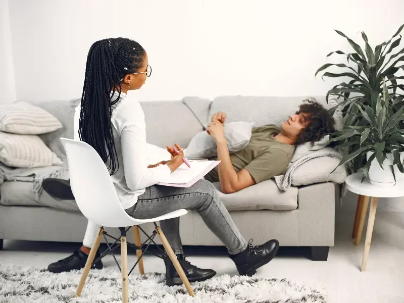 Integrative medicine patient receives counseling on a sofa during a holistic mental health consultation.