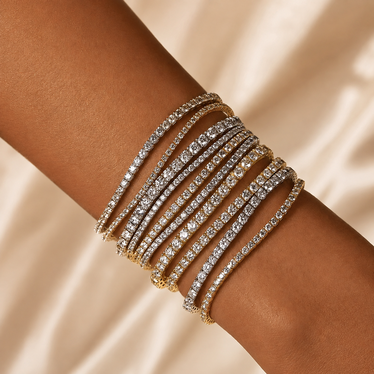 Multiple white and yellow gold diamond tennis bracelets adorned with sparkling gemstones on a person's wrist.
