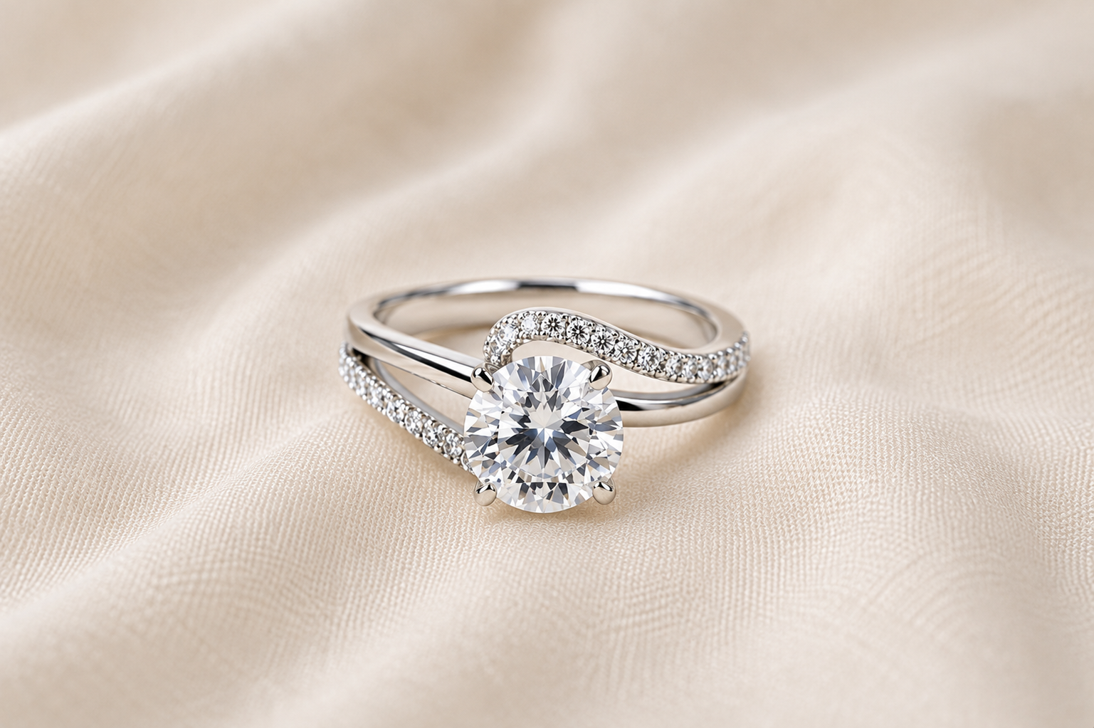 A silver ring with a large round diamond and smaller diamonds on the band, placed on a beige satin fabric.