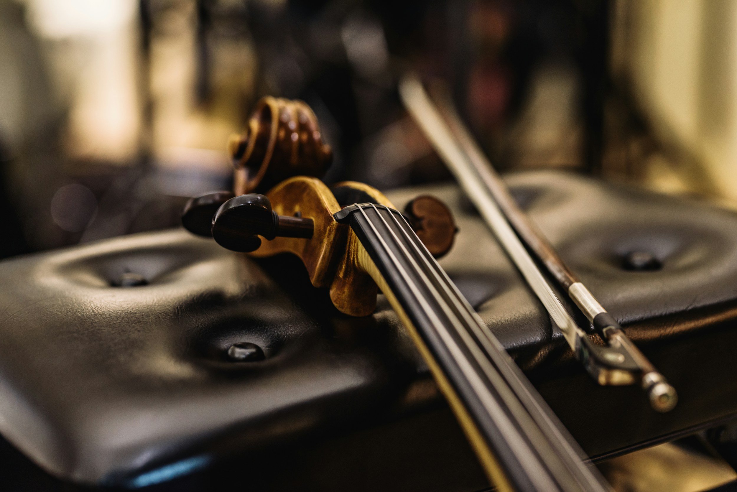 Close-up of a violin resting on a stand or surface, with a blurred background.