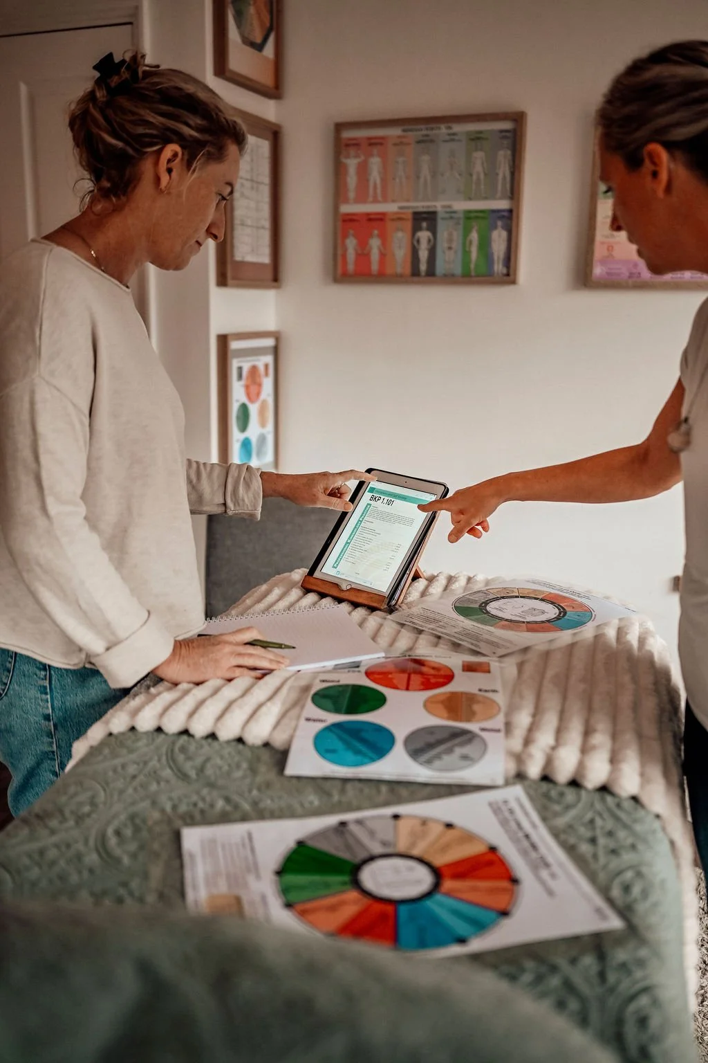 Two women, a teacher and student analysing charts related to kinesiology education