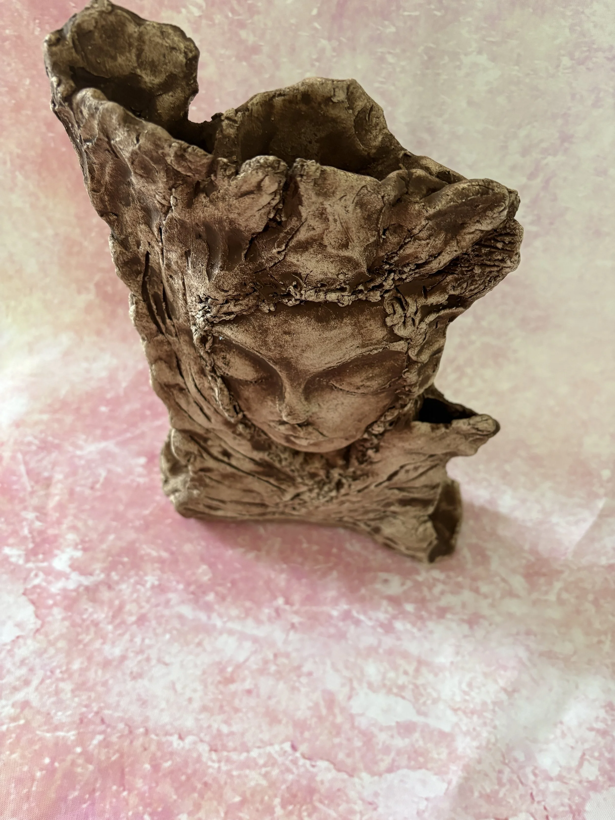 Face of a woman, embedded in a tree.