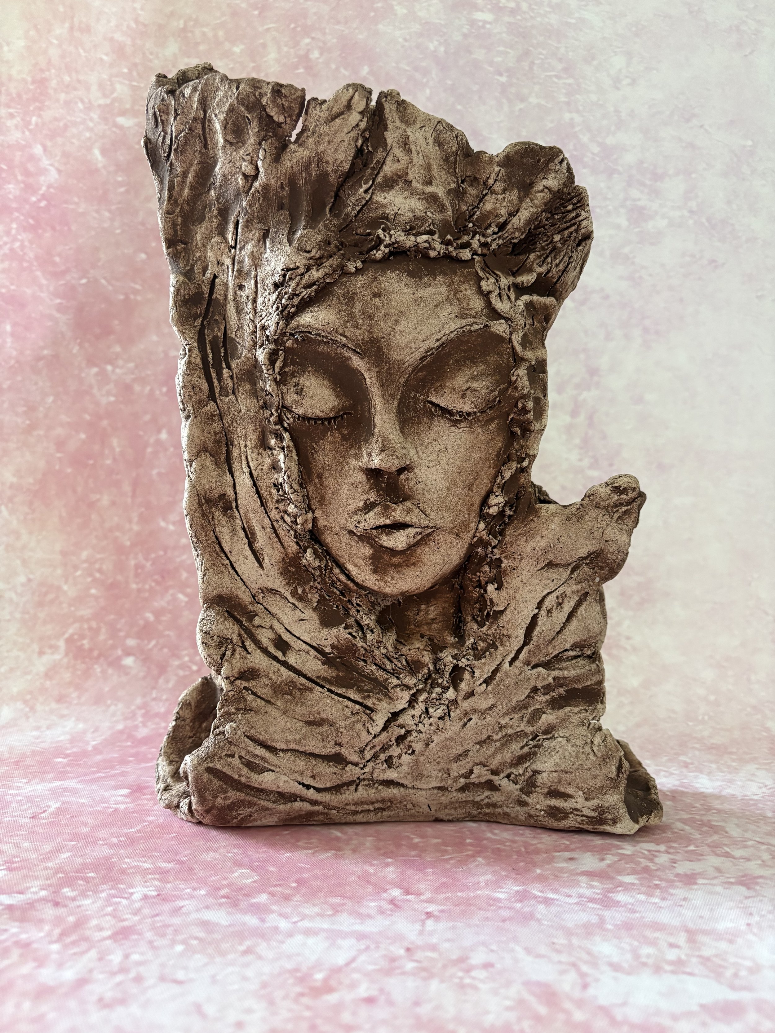 Face of a woman, embedded in a tree.