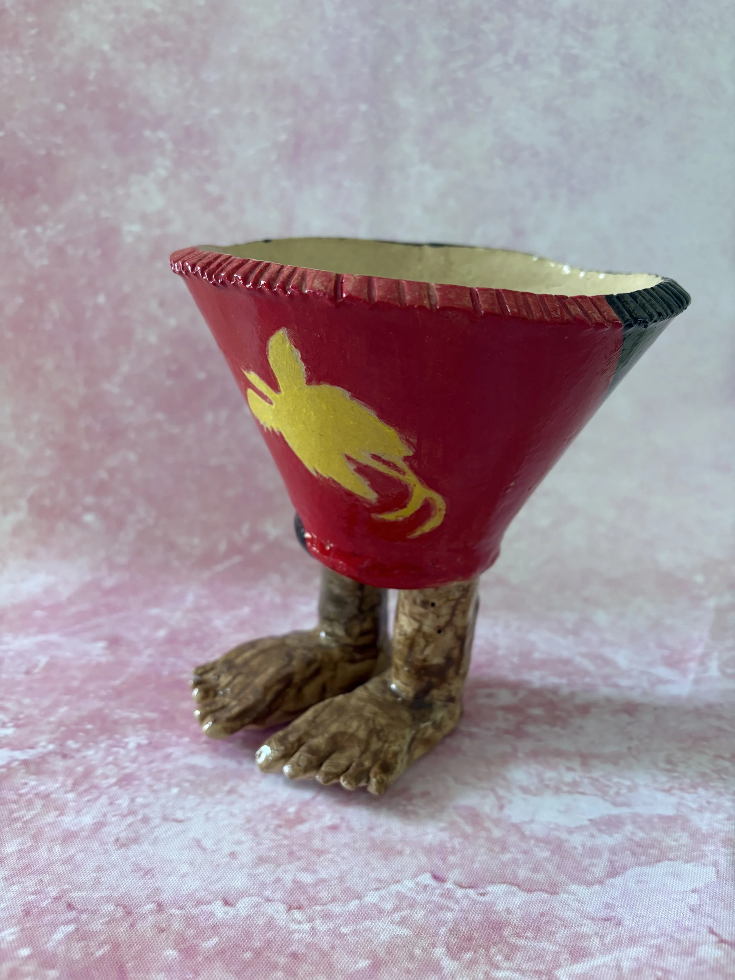 Plant pot with human feet, decorated with the Papua New Guinea flag.
