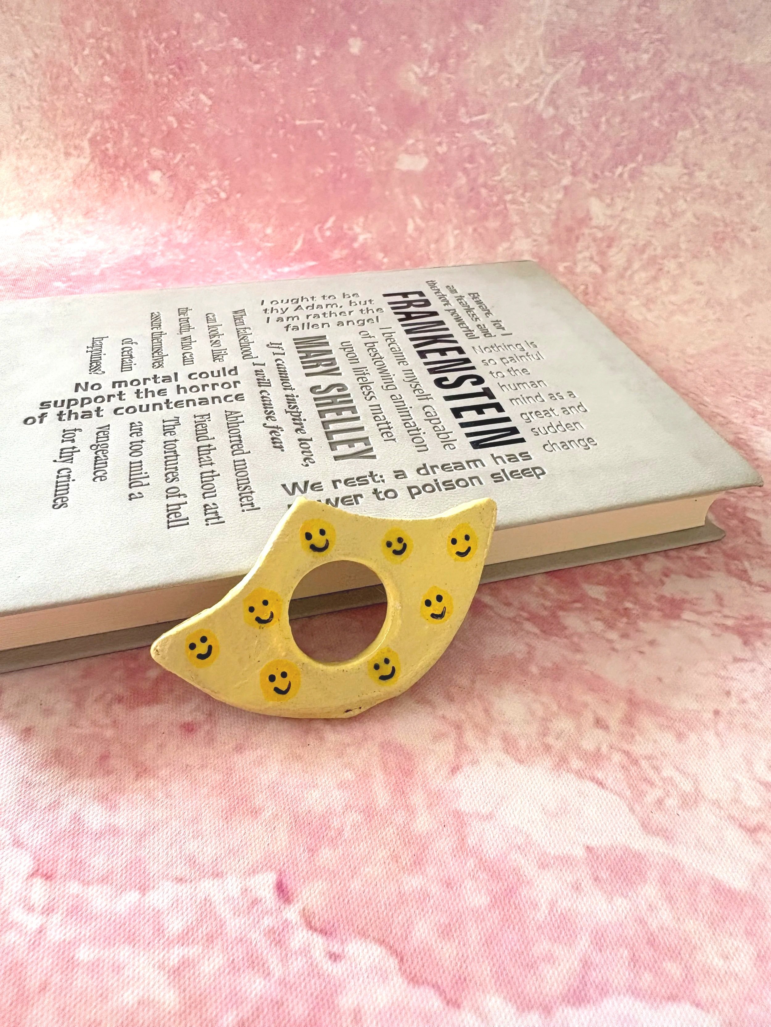 Yellow smiley face patterned page holder.