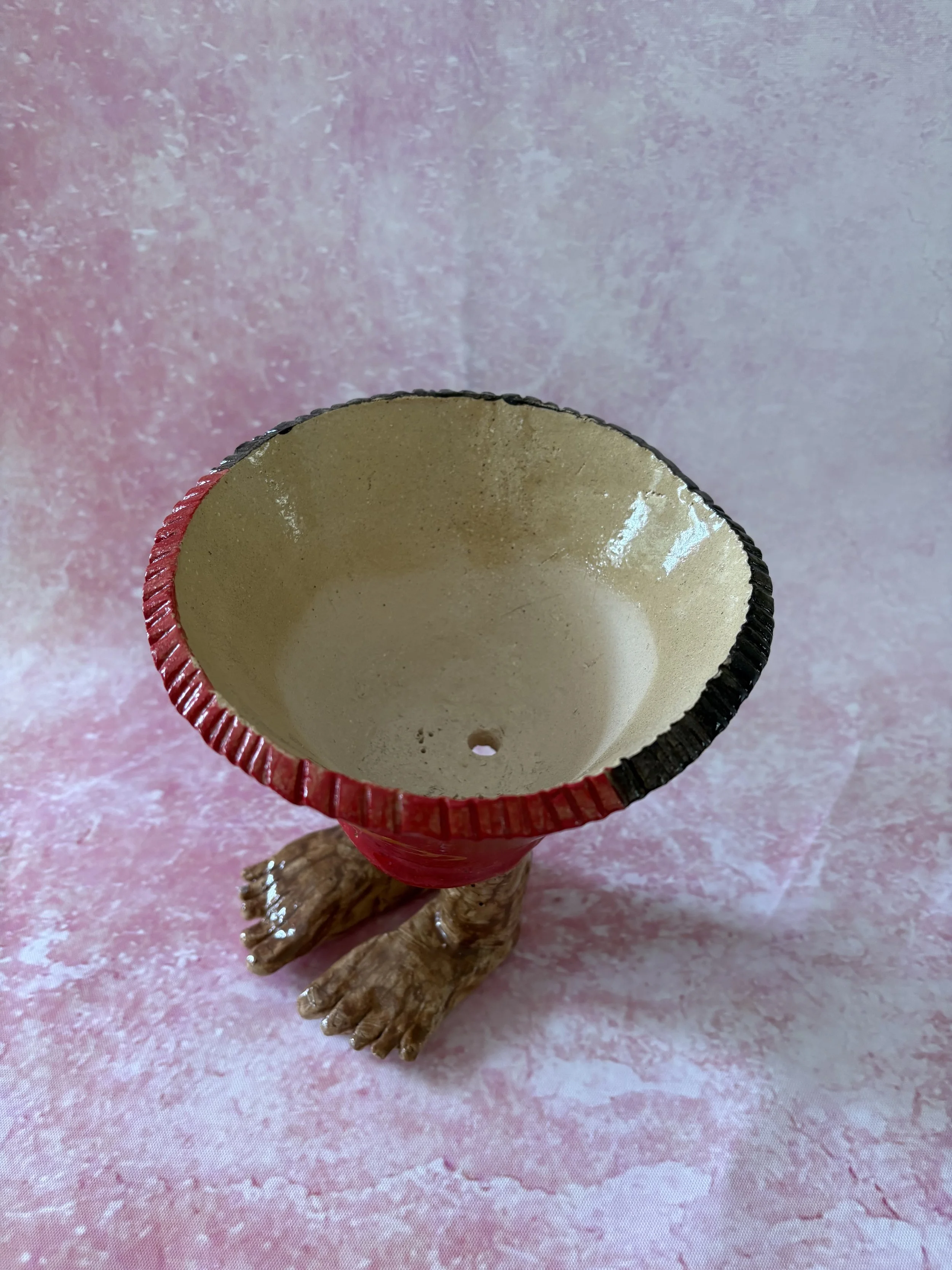 Plant pot with human feet, decorated with the Papua New Guinea flag.