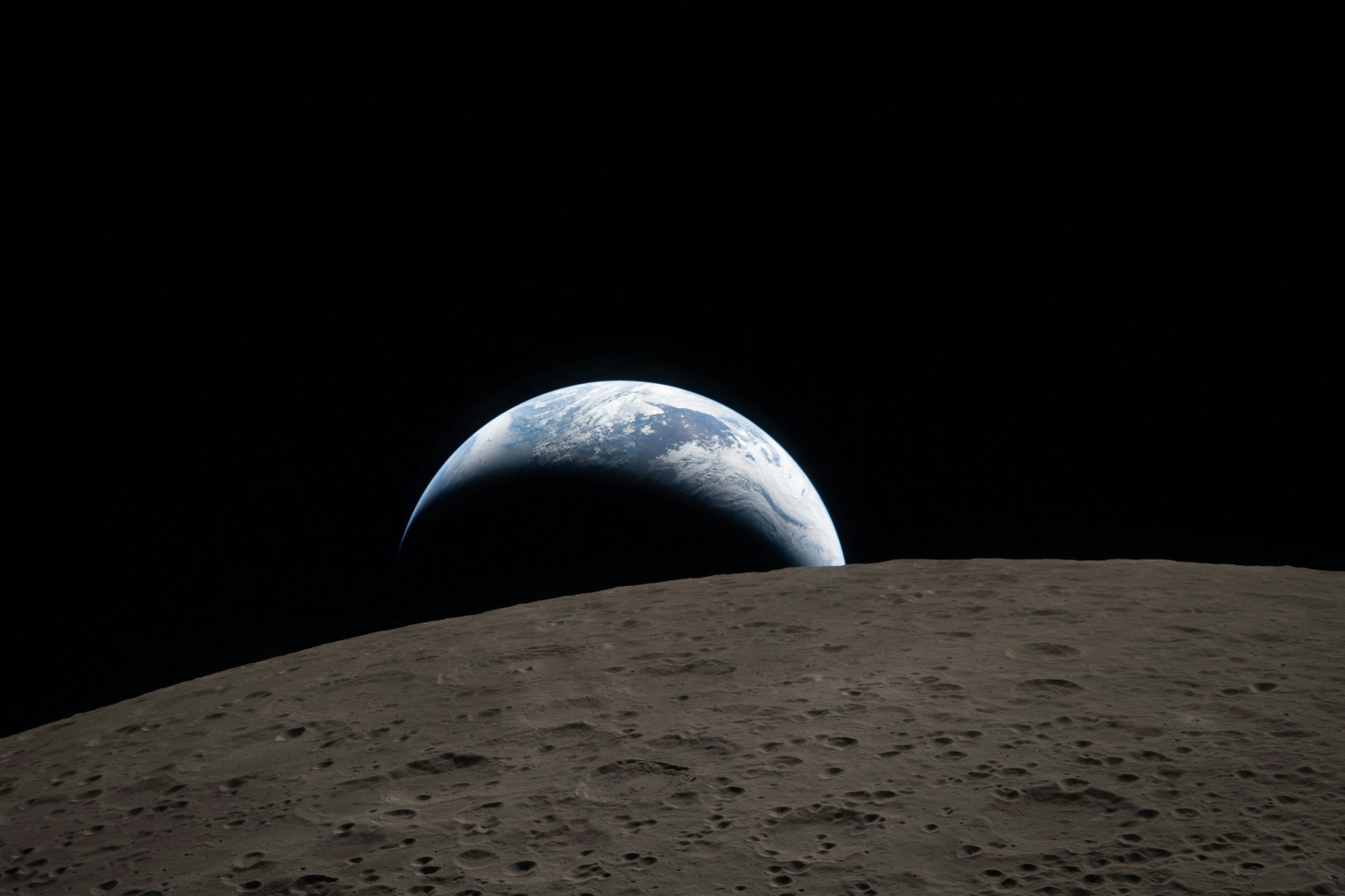 View of Earth rising over the lunar surface seen from the moon.