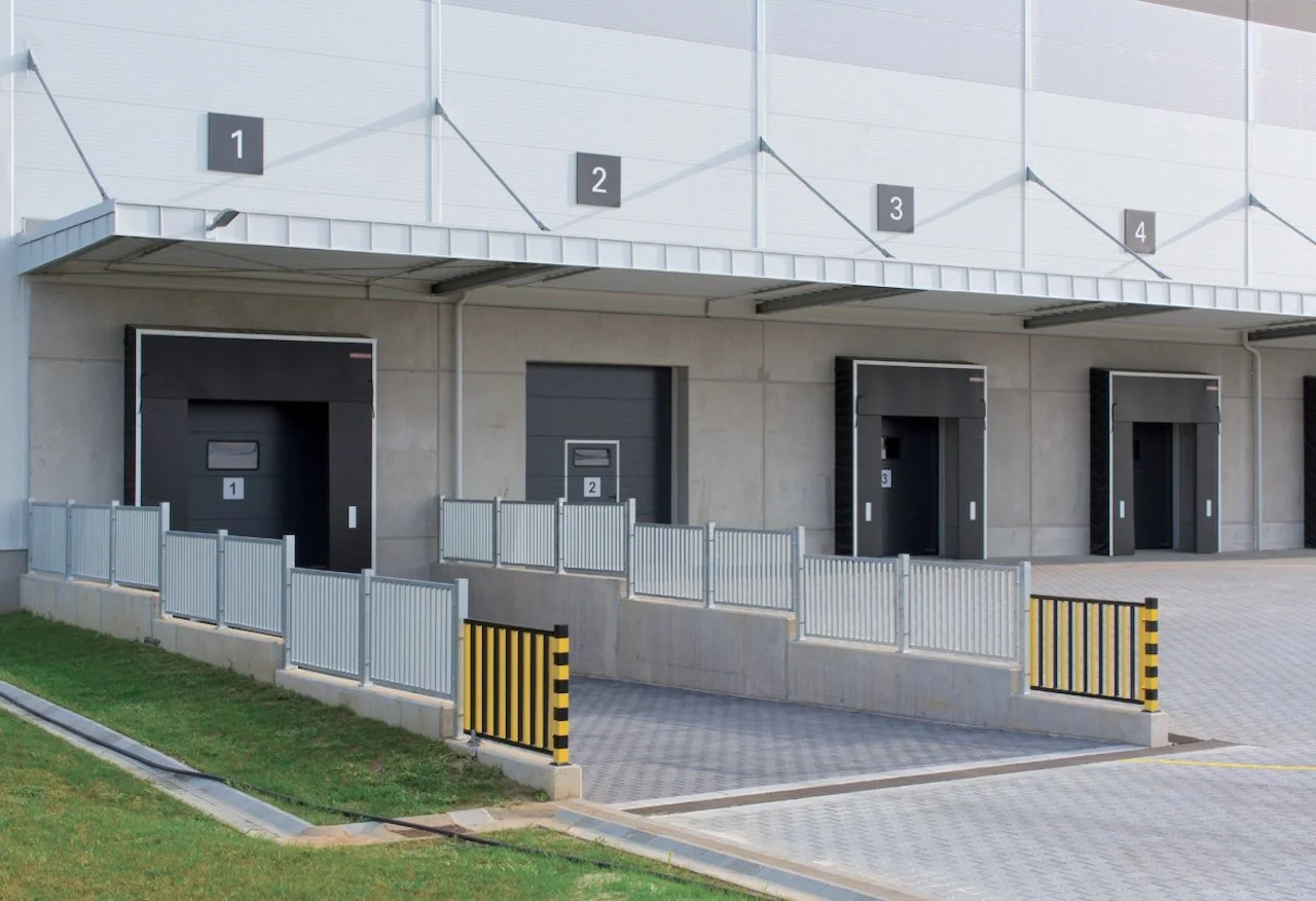 Loading docks with numbered doors and barriers, part of a warehouse or distribution center.