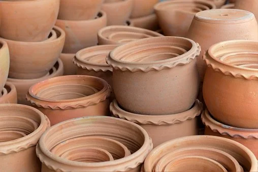 Multiple unglazed clay flower pots stacked and arranged on a surface.