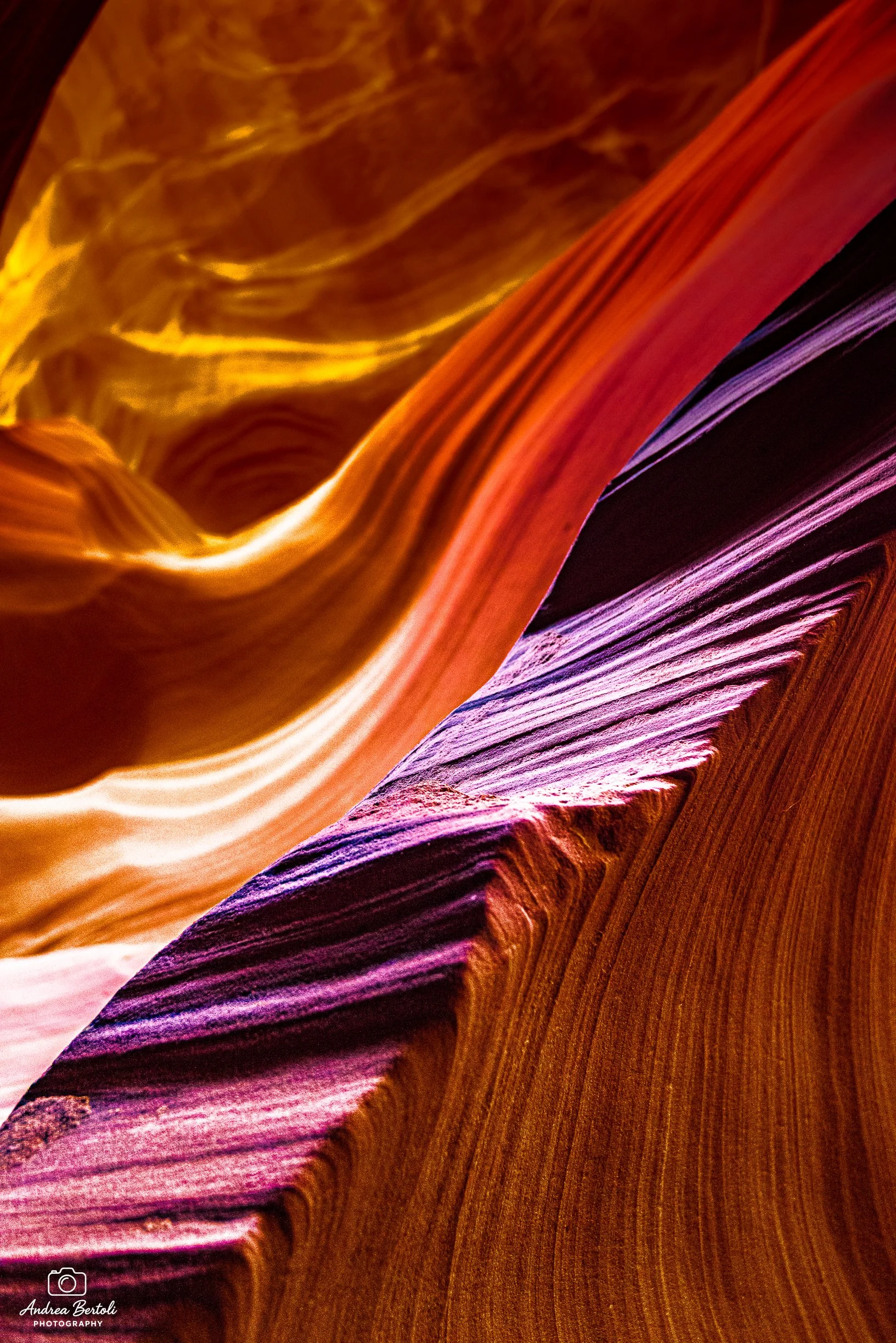 Immagine che mostra le pareti all'interno dell'Antelope Canyon, con colori caldi come arancio, giallo e viola, e curve scolpite dall'erosione.