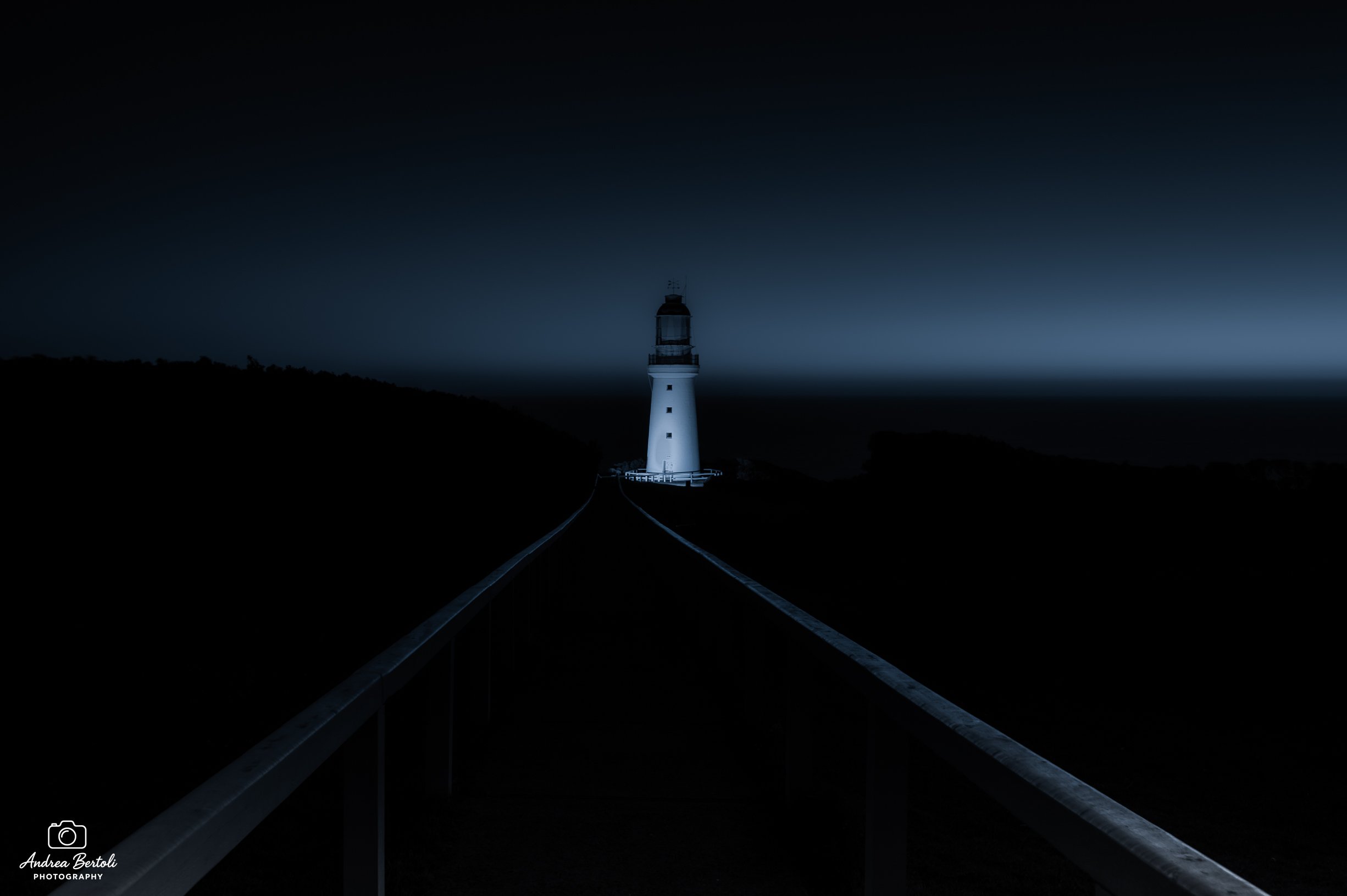 Faro a Cape Otway al tramonto, visibile da un binario ferroviario vuoto.