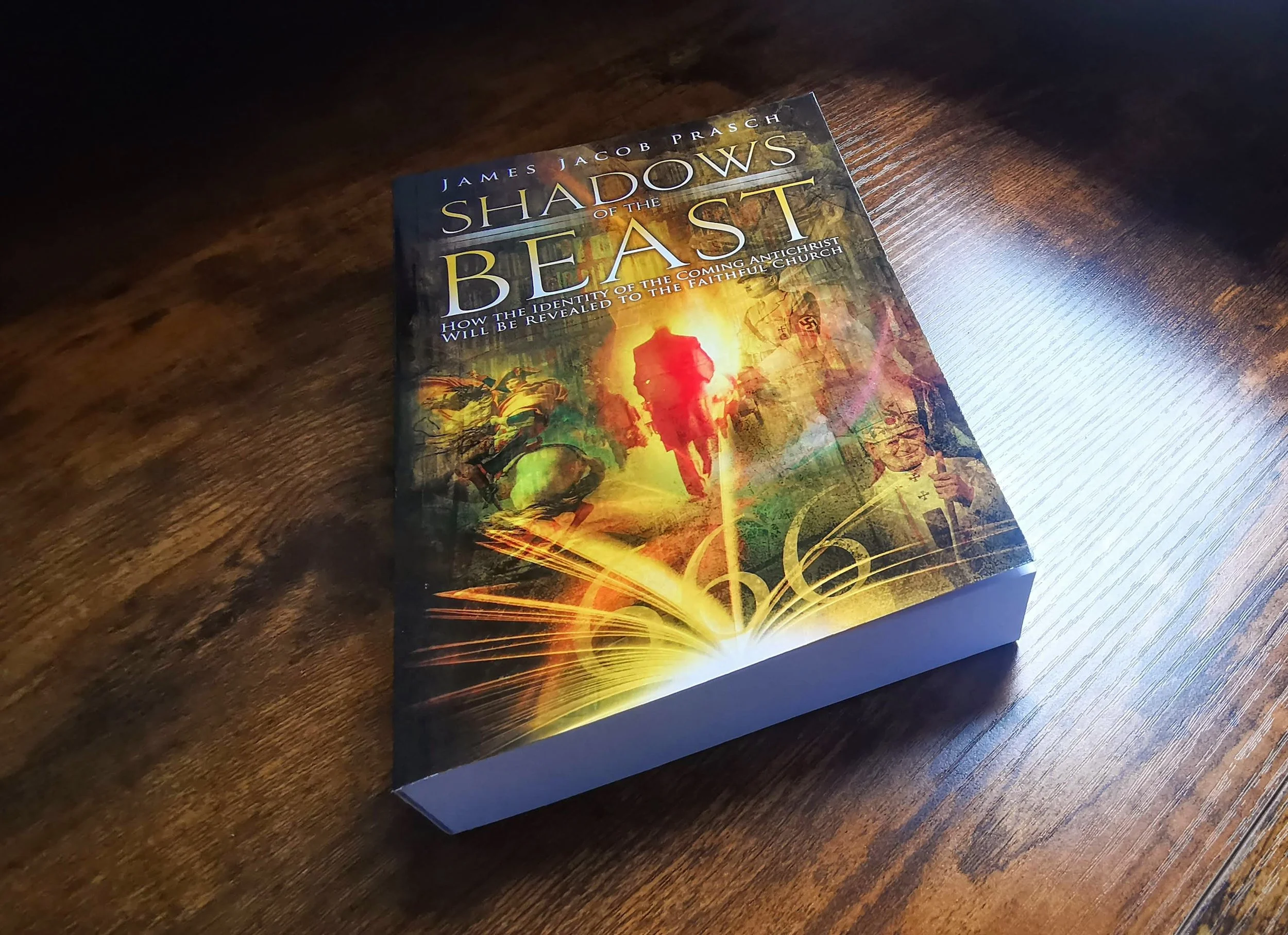 A book titled 'Shadows of the Beast' by James Jacob Prasch resting on a wooden surface, with colorful cover art depicting figures and flames.