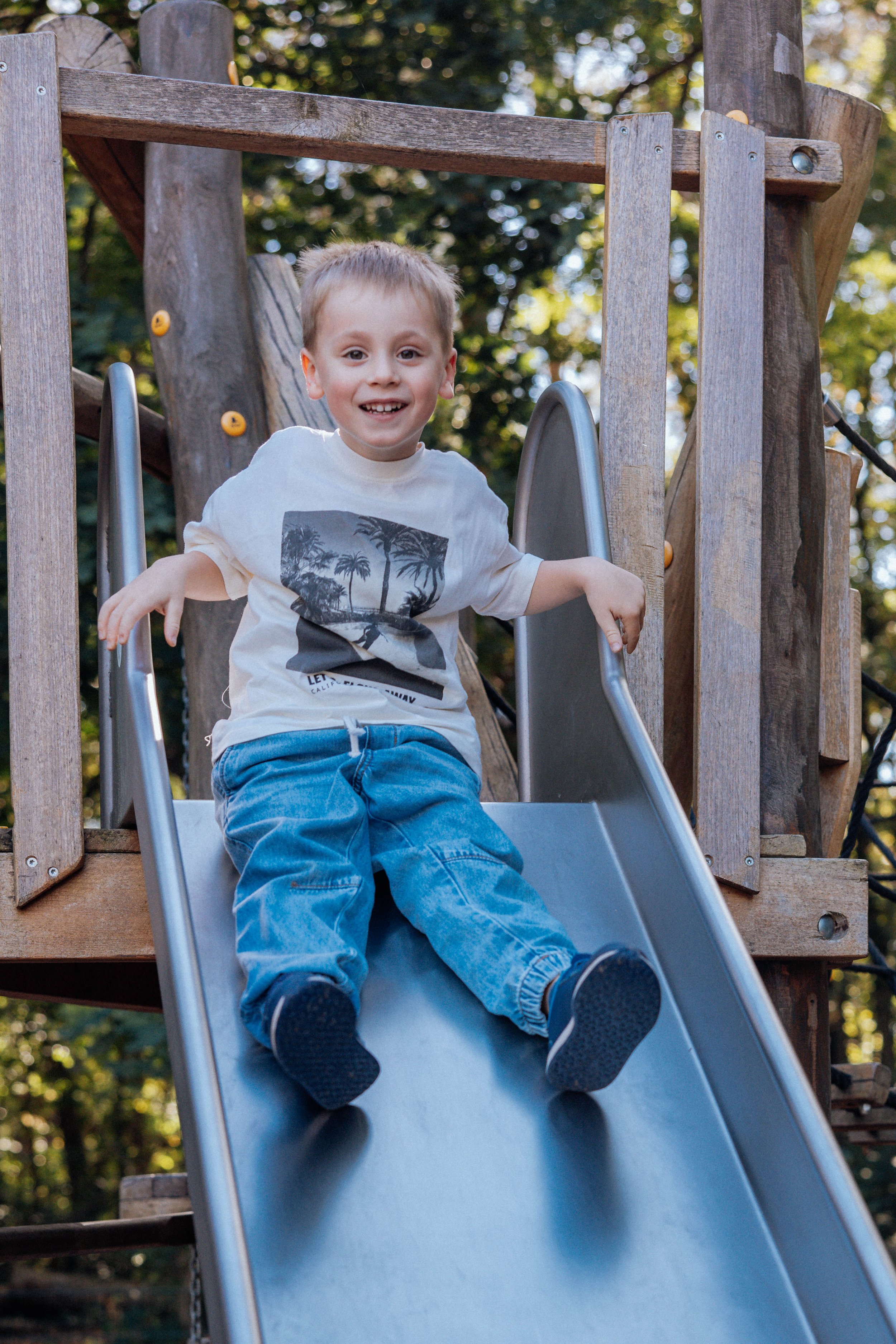 Ein Junge beim Rutschen auf einem Spielplatz in der Kita in Brandenburg.