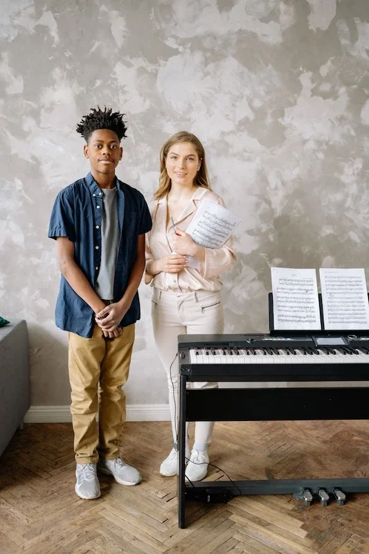 Two music students at a piano