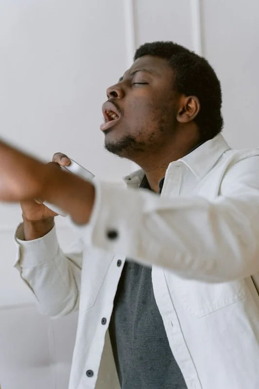 An adult guy singing.