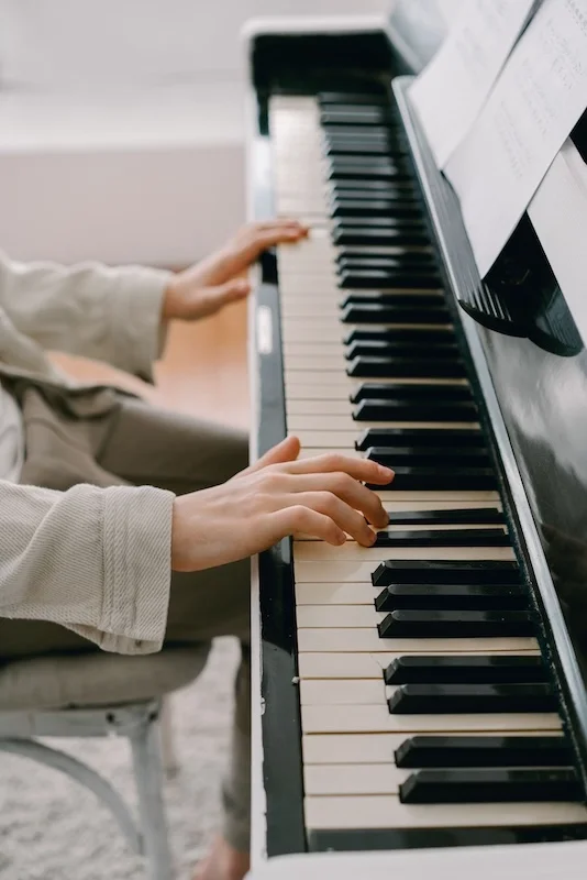 Close up of hands on a piano.