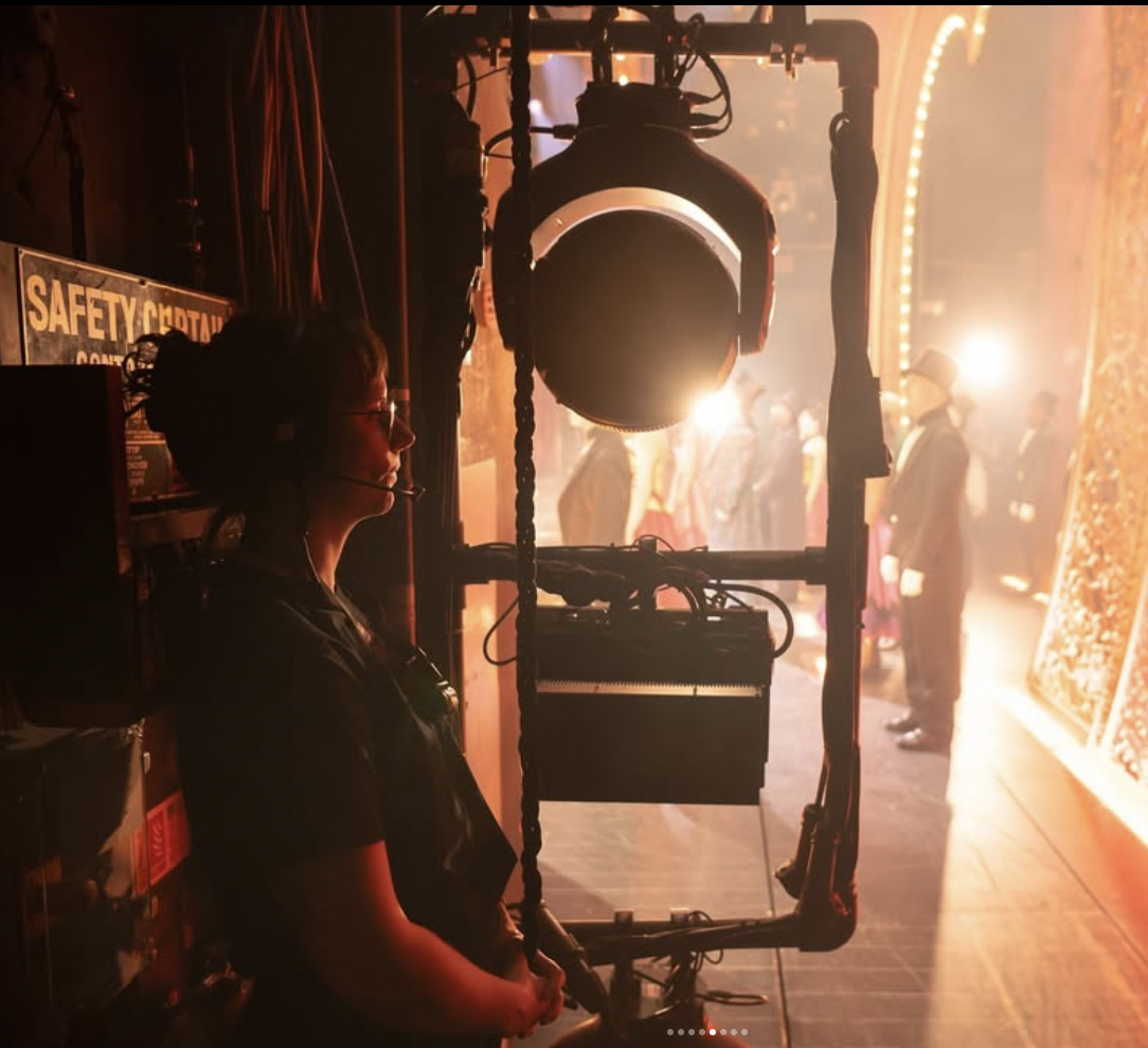 Hannah is standing in the wings, looking onto the stage, watching the West End musical Moulin Rouge