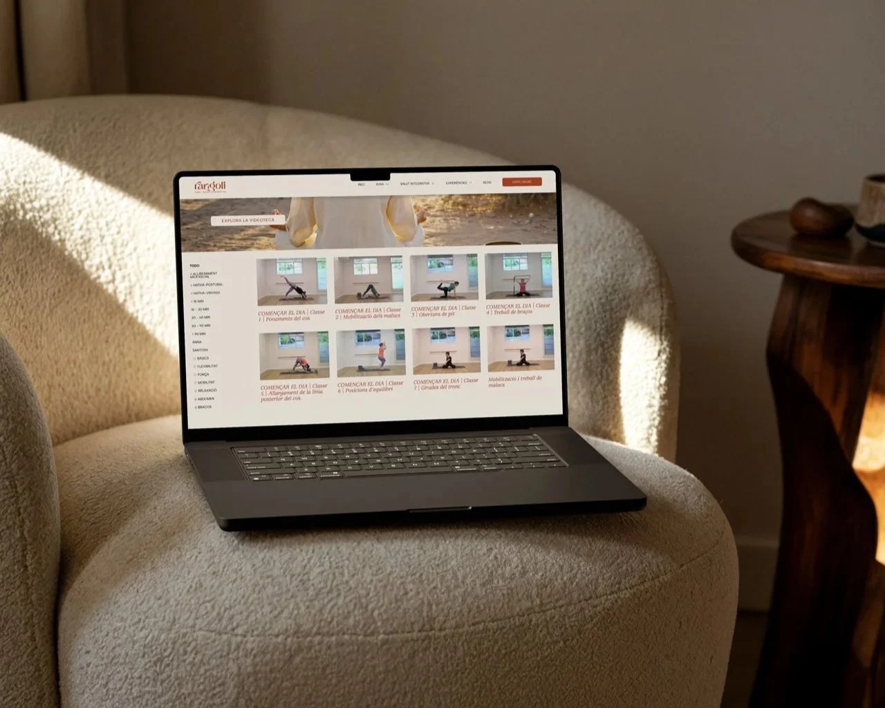 Portátil en un sillón reproduciendo una plataforma de yoga en línea.