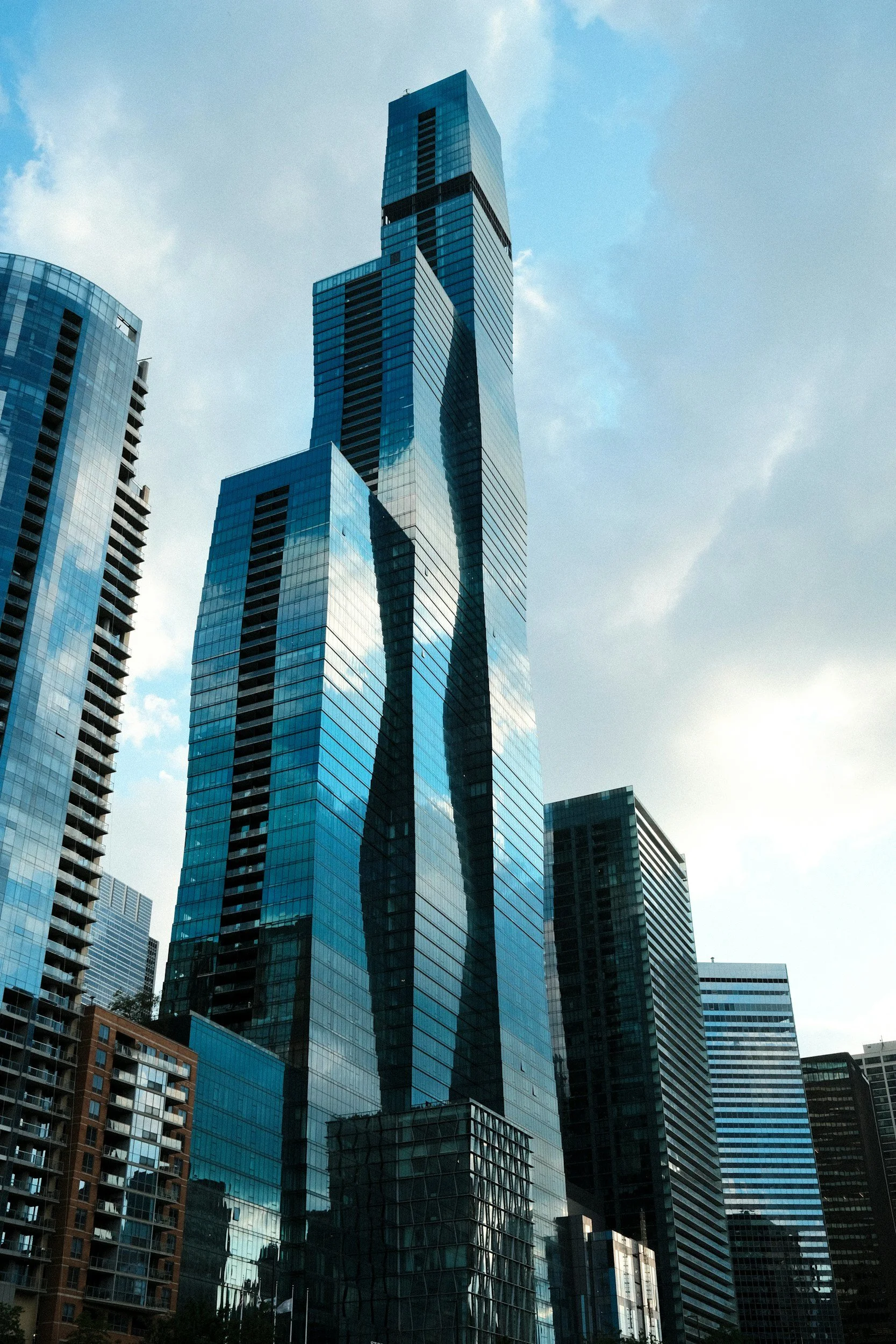 Tall modern skyscrapers with glass facades reflecting the sky in a cityscape.